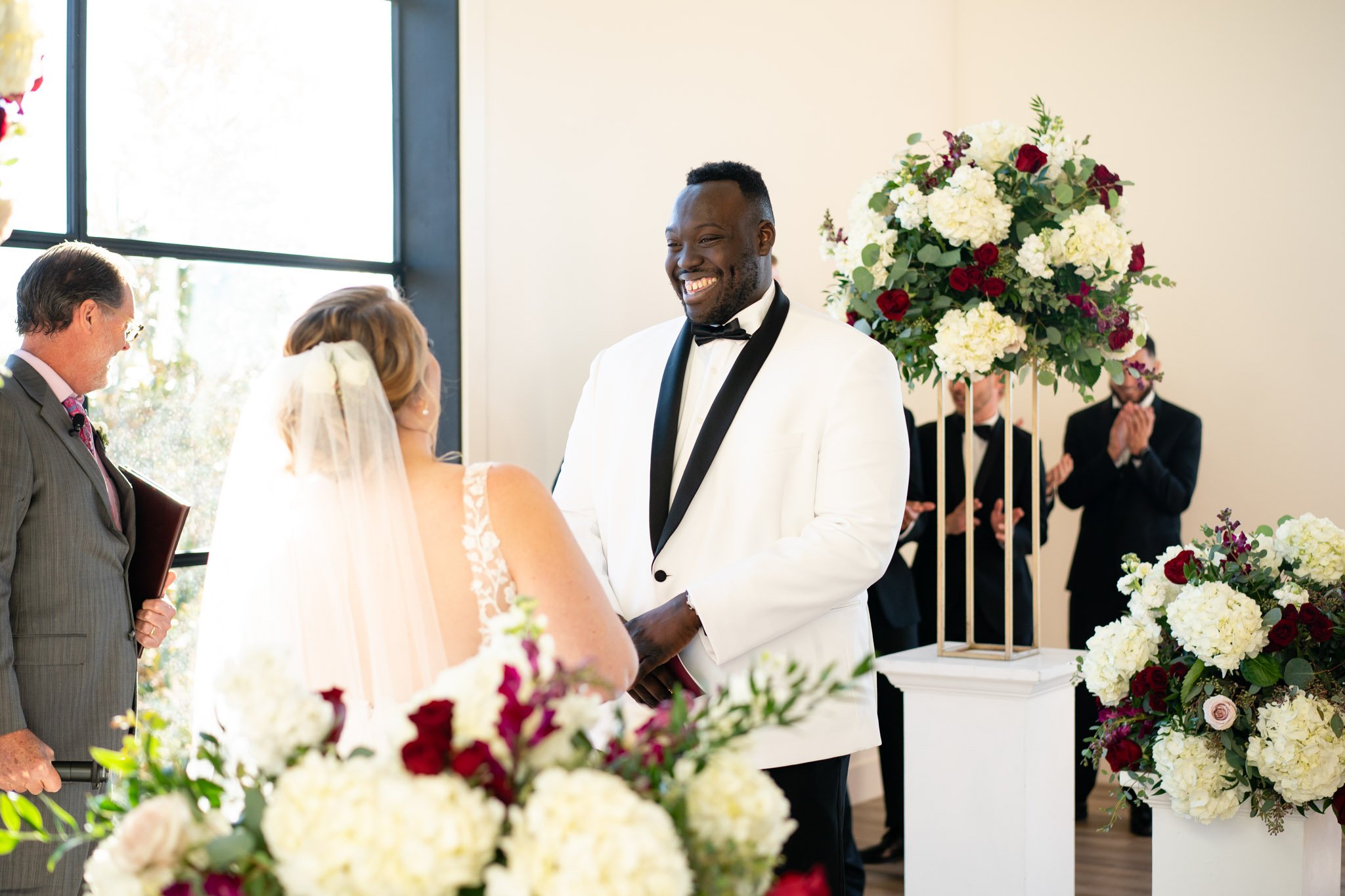 Groom smiling wide at the bride before the officiant at The Arlo in Texas The Amber Studio