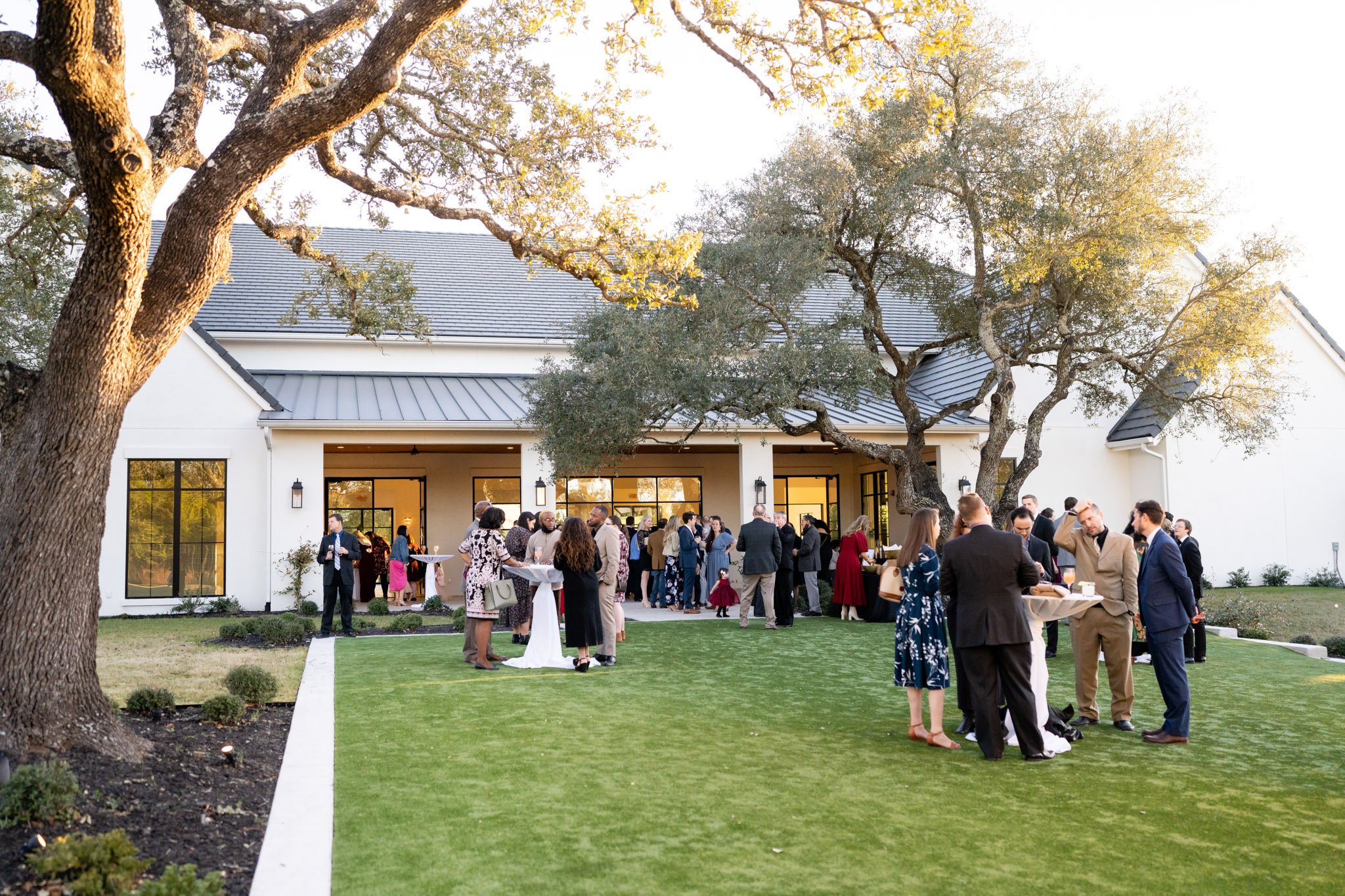 Wedding guests mingling in a grassy field just outside the Arlo in Austin TX The Amber Studio