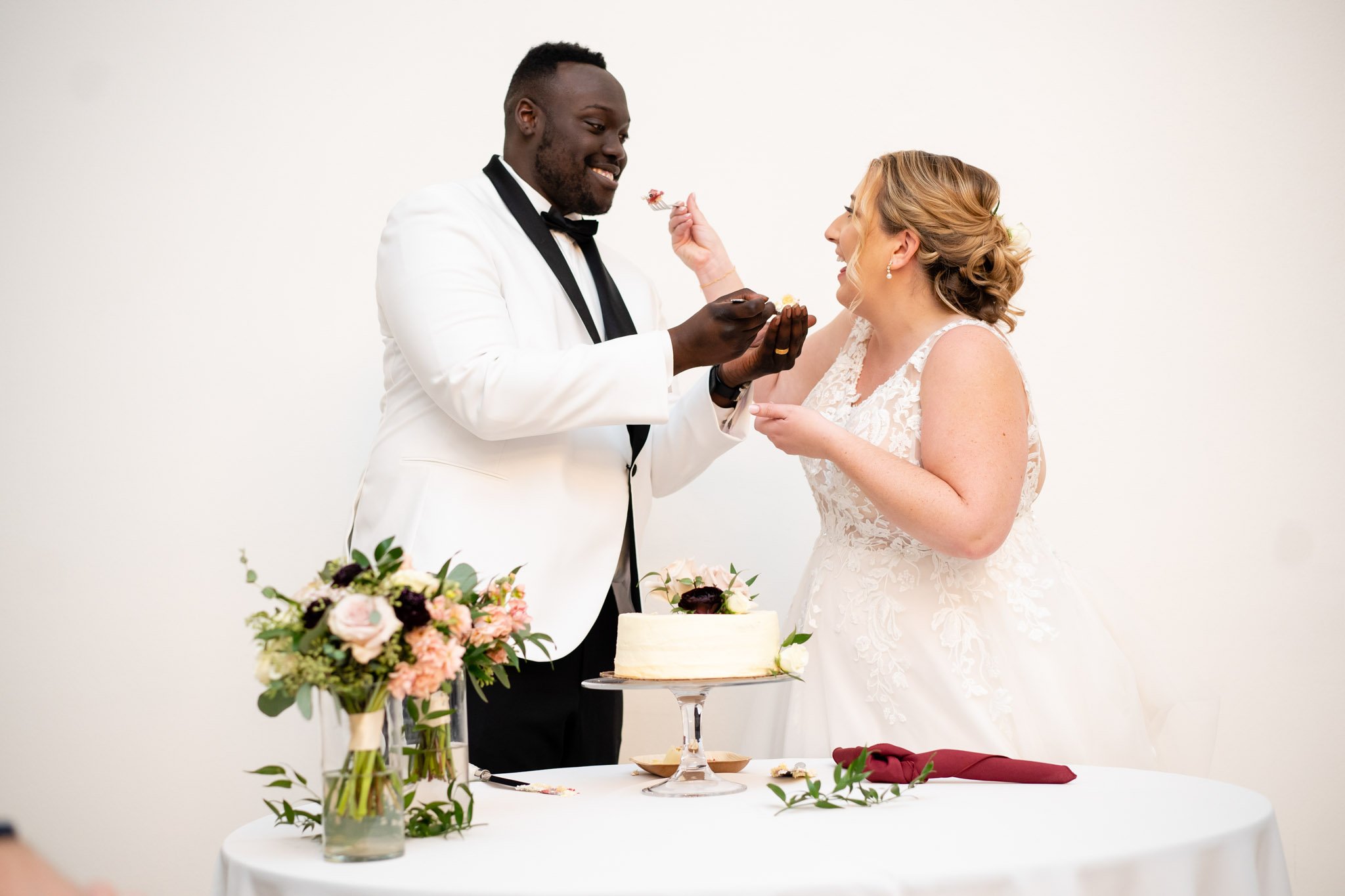 Newly married couple feeds each other wedding cake at The Arlo in Texas The Amber Studio