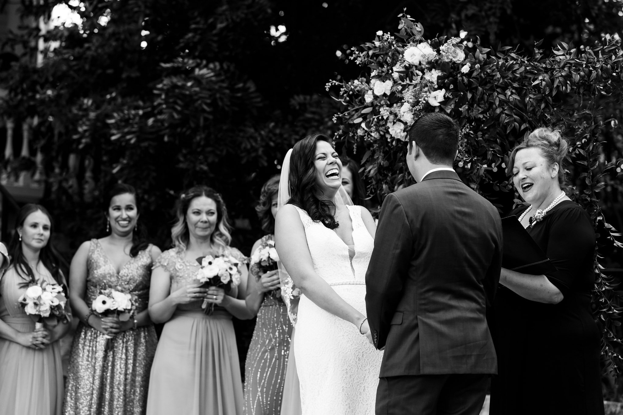 A bride laughs by the officiant during the wedding ceremony outside in DFW Texas The Amber Studio