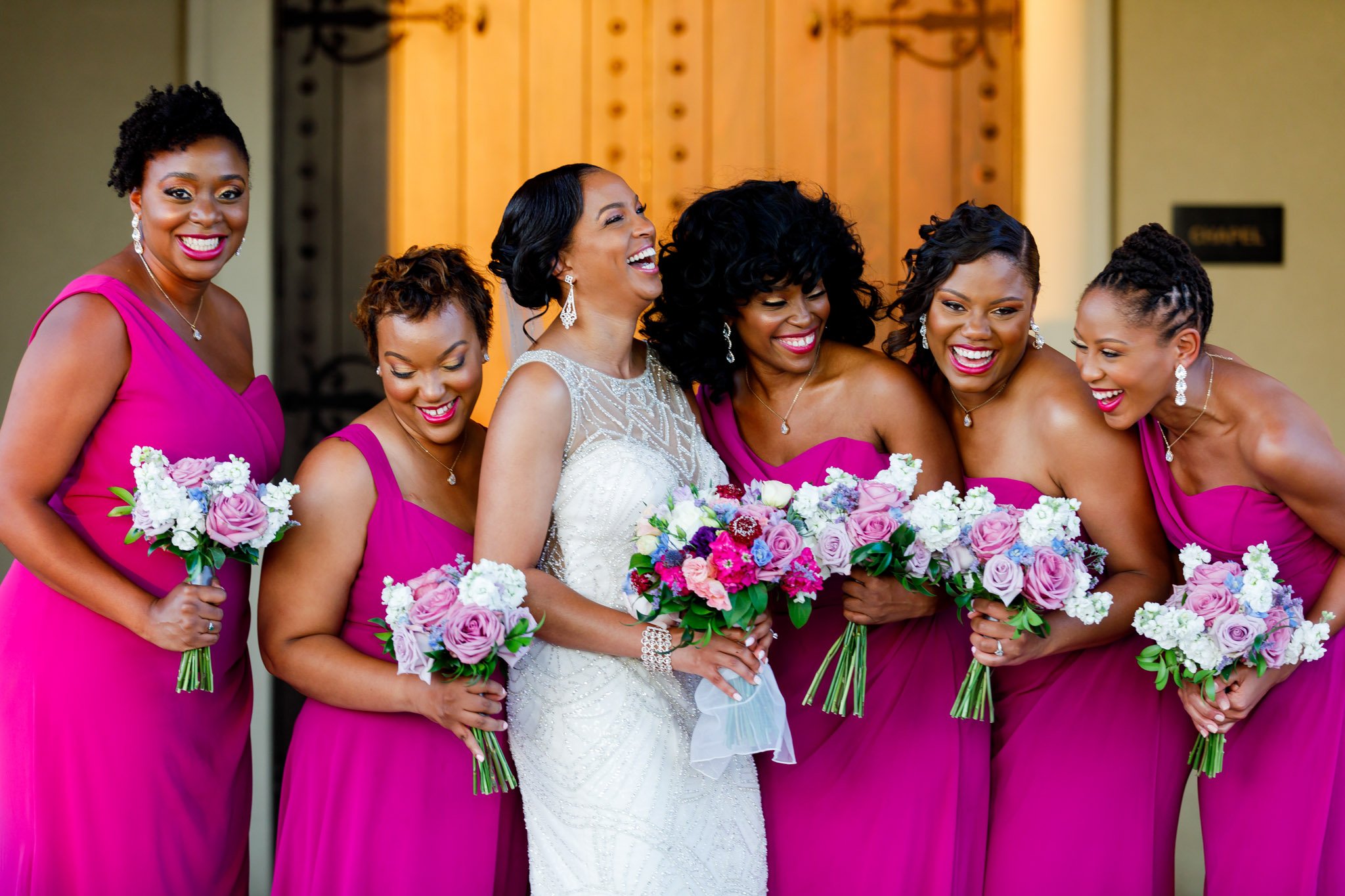 A bride laughing with attendants holding white and pink bouquet in Dallas Fort Worth The Amber Studio