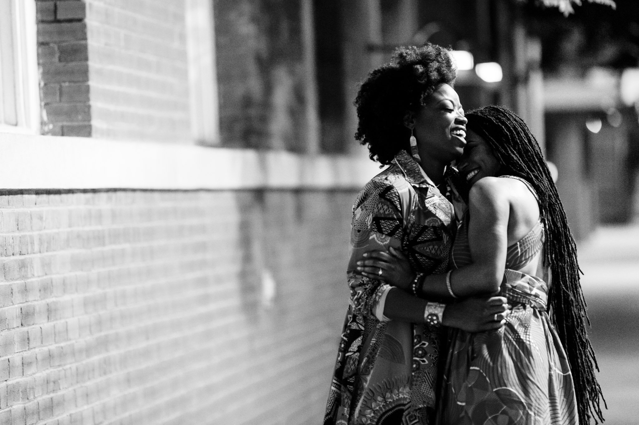 Wedding guests laugh and embrace outside the reception in Dallas Fort Worth Texas The Amber Studio