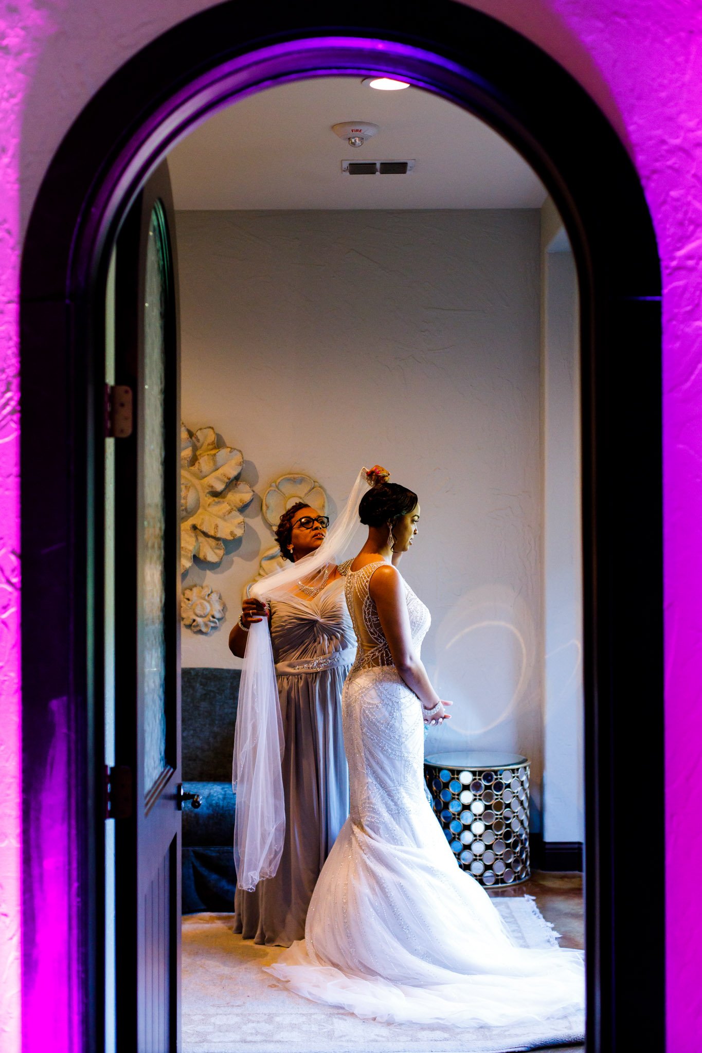 An attendant helping to put on the brides veil in a hotel in Dallas Fort Worth TX The Amber Studio