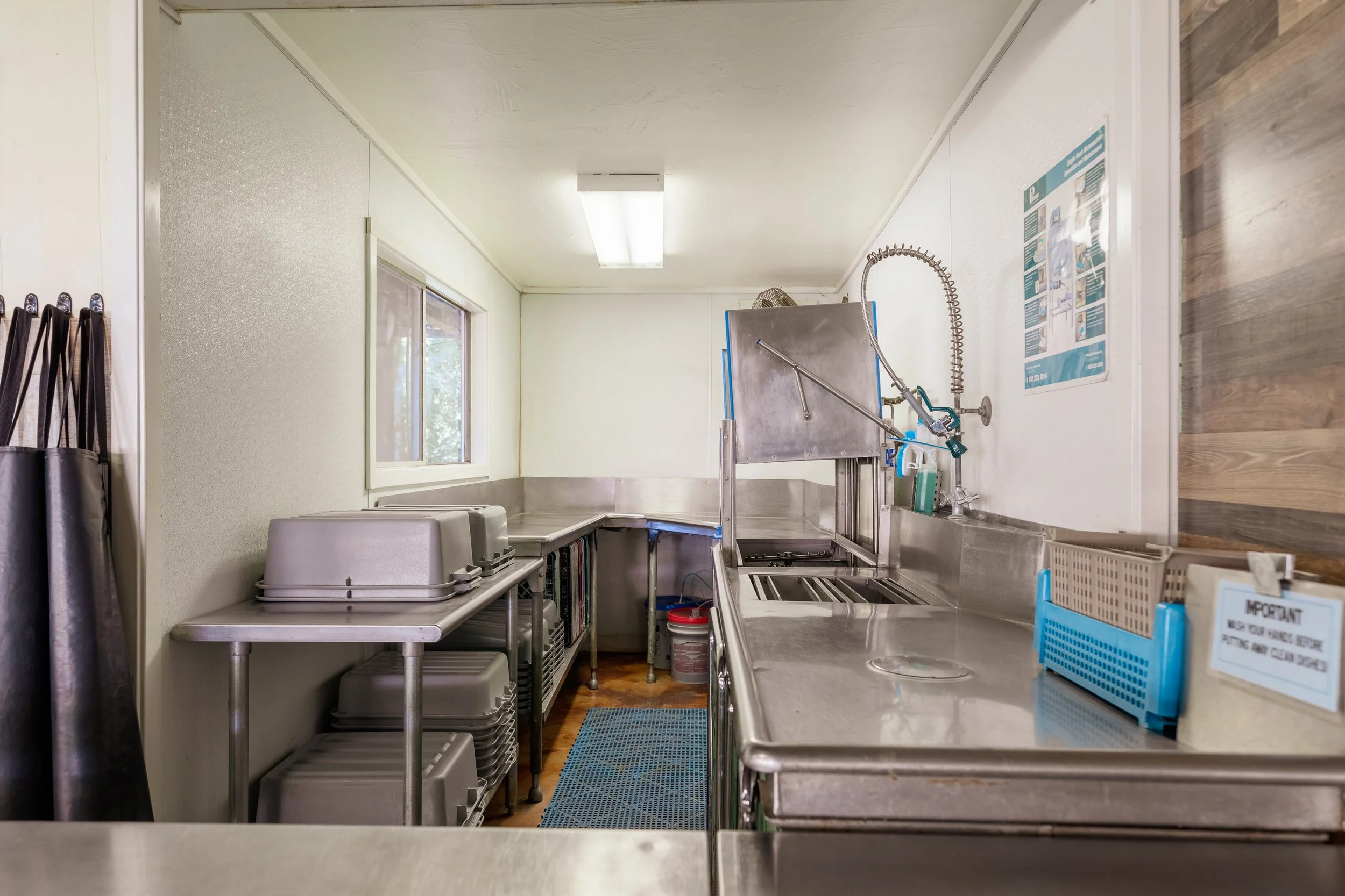 Dish washing station of the kitchen. Plenty of counter space, a large cleaning area, and a sanitizer.