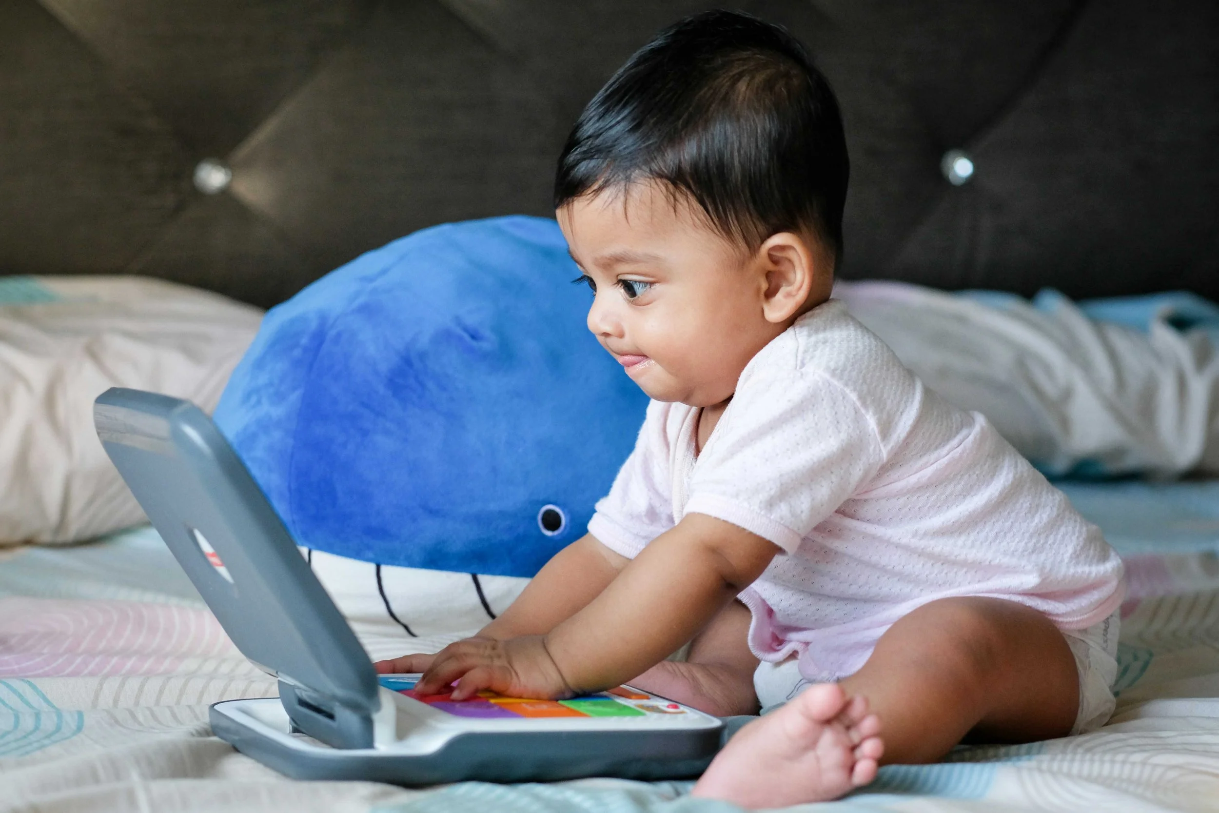 Baby doing baby massage course online on laptop