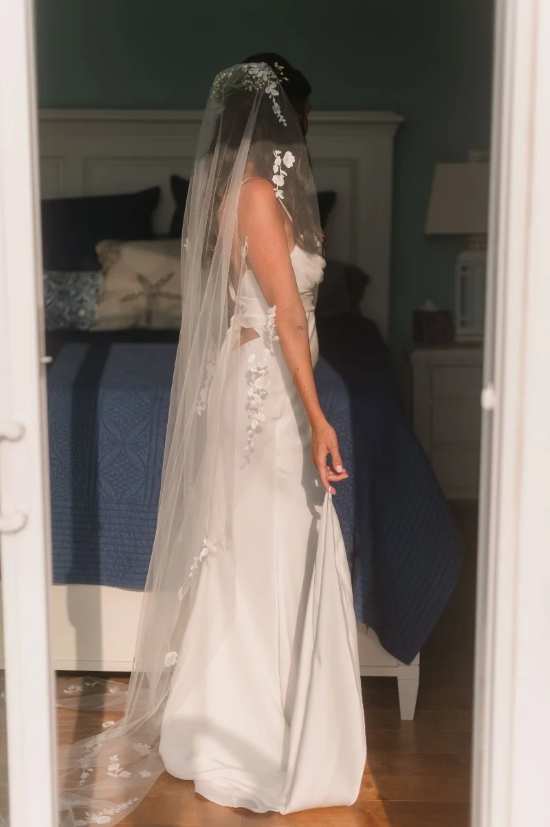 Person wearing a white wedding dress and floral veil, offering beautiful inspiration for wedding dress tips.
