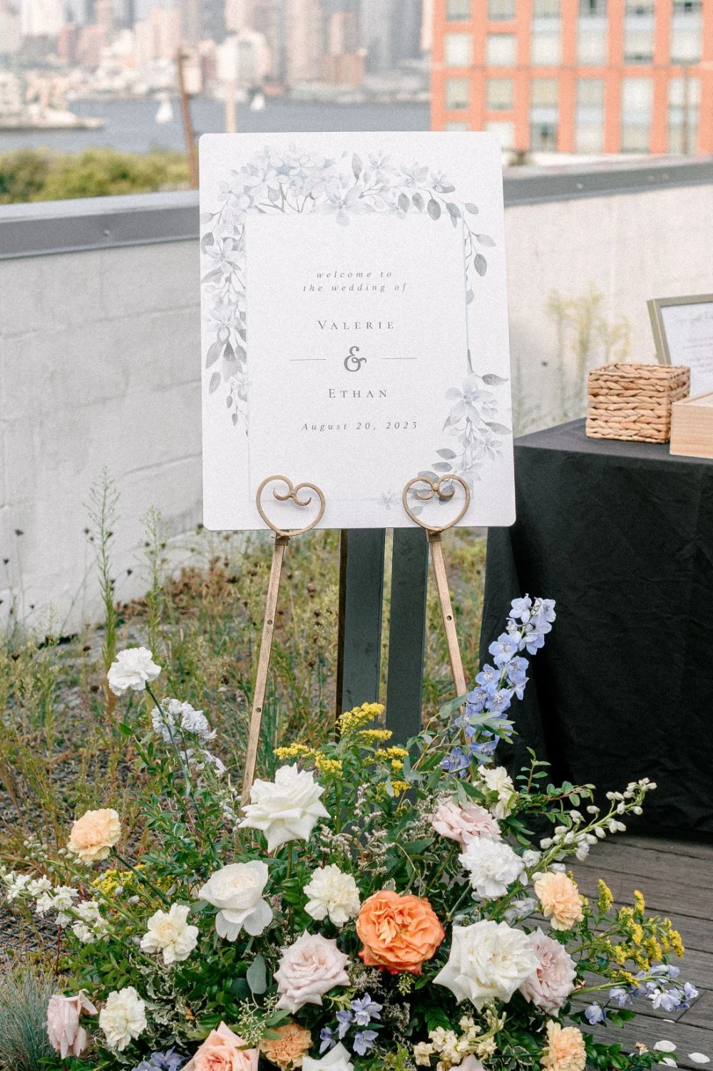Wedding detail photos featuring a personalized welcome sign with floral accents and gold heart-shaped stands.
