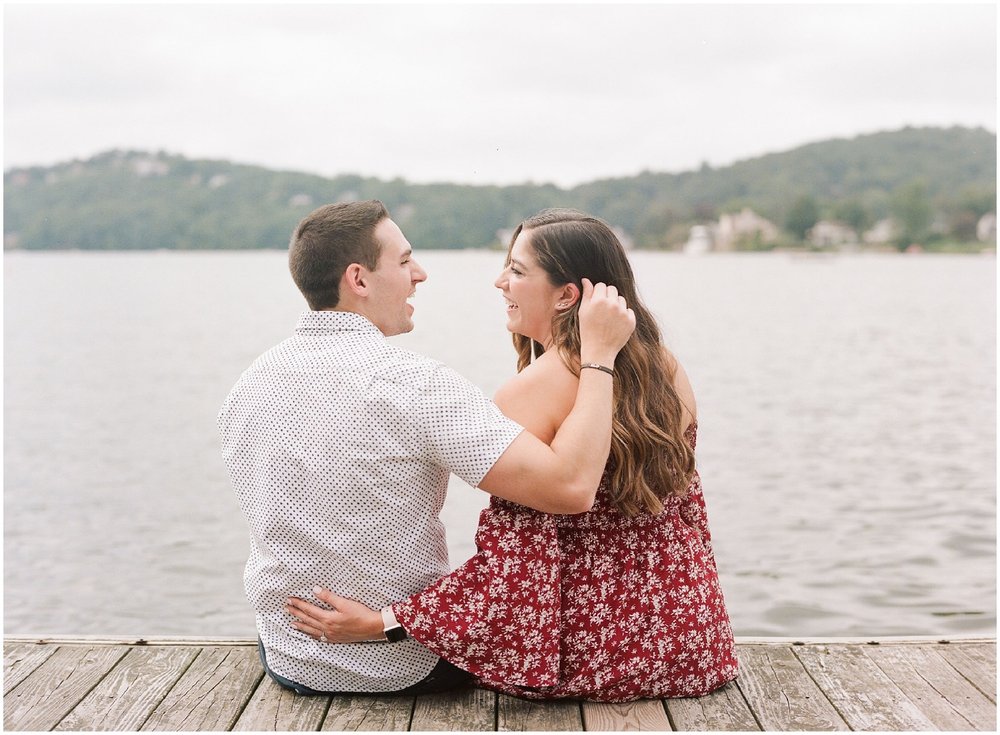 secret proposal, northern new jersey, newly engaged couple smiling and laughing, having fun on the boardwalk near the lake