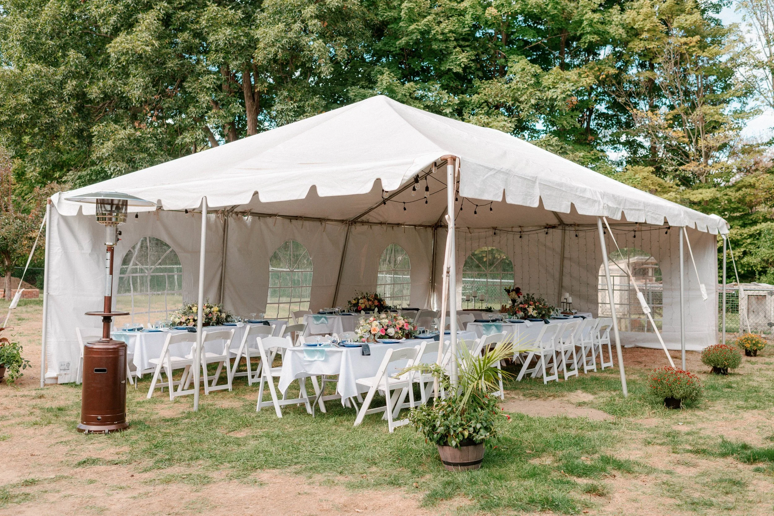  Elegant outdoor tented reception with white tables, colorful floral centerpieces, and string lights, ideal for a cozy micro wedding in New Jersey. 