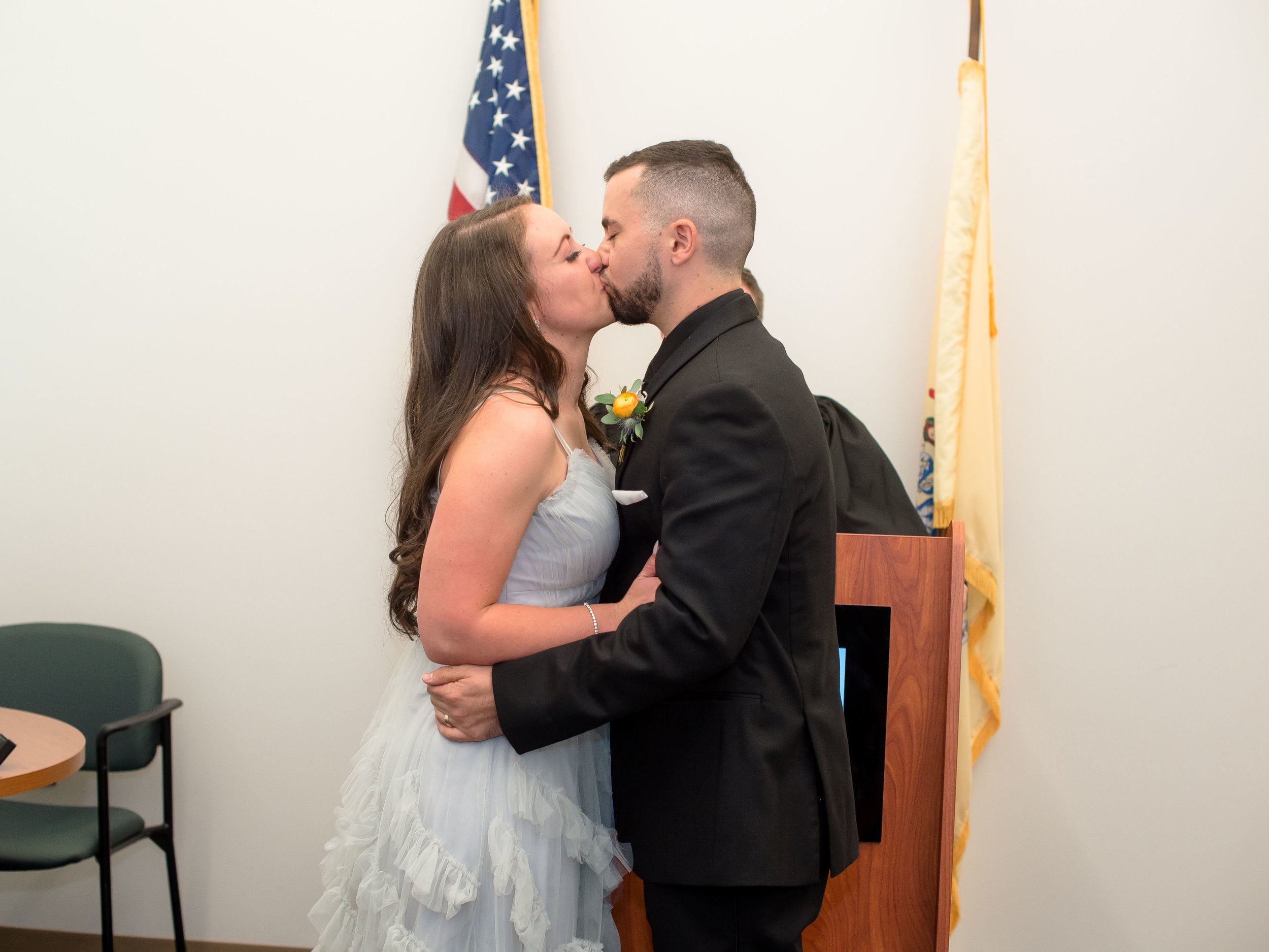  Bride and groom share their first kiss during an intimate City Hall wedding ceremony in New Jersey, celebrating their elopement with joy and love.   