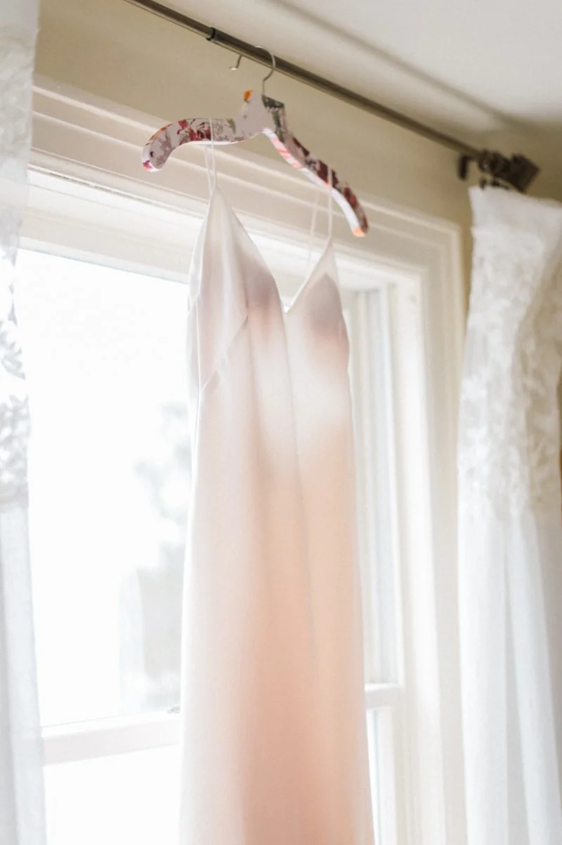  wedding gown hanging up in a window during getting ready wedding photography 
