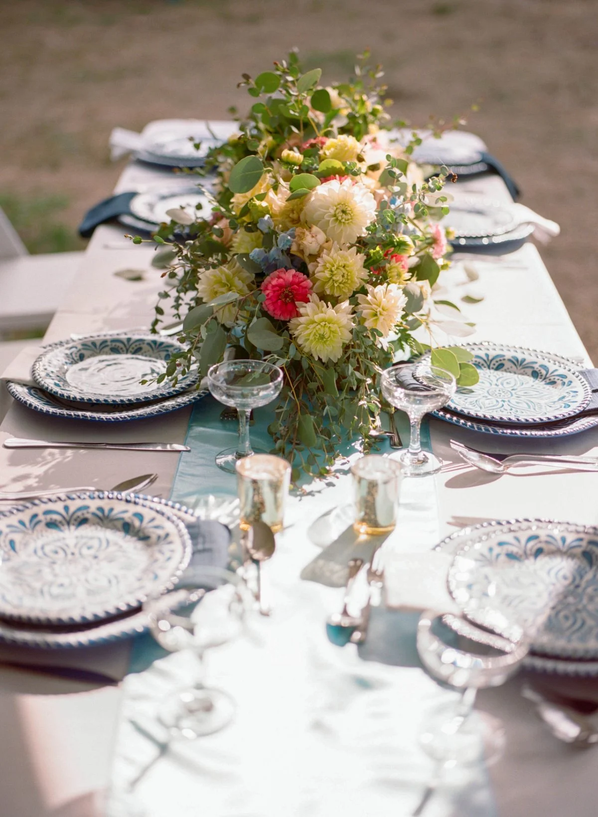  Vibrant florals and blue patterned plates bring a festive, upscale feel to this outdoor intimate wedding table.   