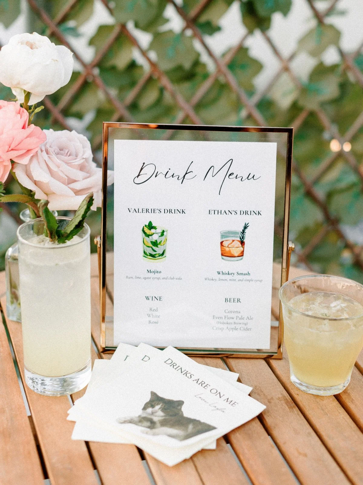  A charming drink menu with signature cocktails and florals adds thoughtful flair to a  luxurious small intimate wedding  bar setup.   
