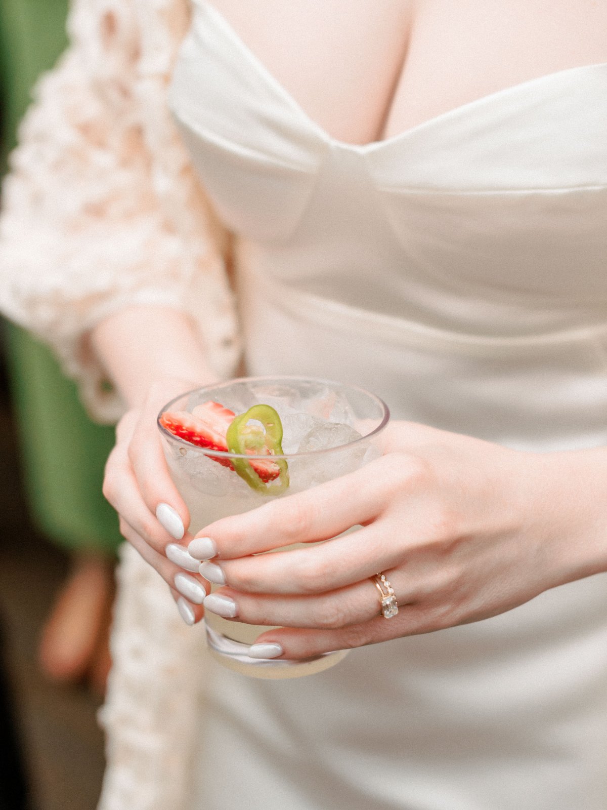 A bride holds a spicy strawberry cocktail—fun flavors and custom drinks are a sweet highlight of any  luxurious small intimate wedding .   
