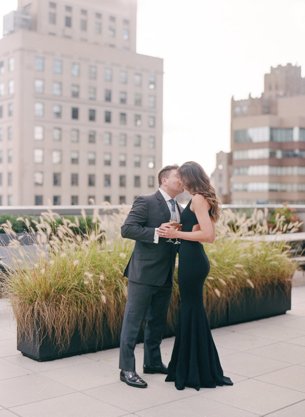  Romantic rooftop engagement photo with classic black outfits and soft what to wear for engagement photos inspiration. 