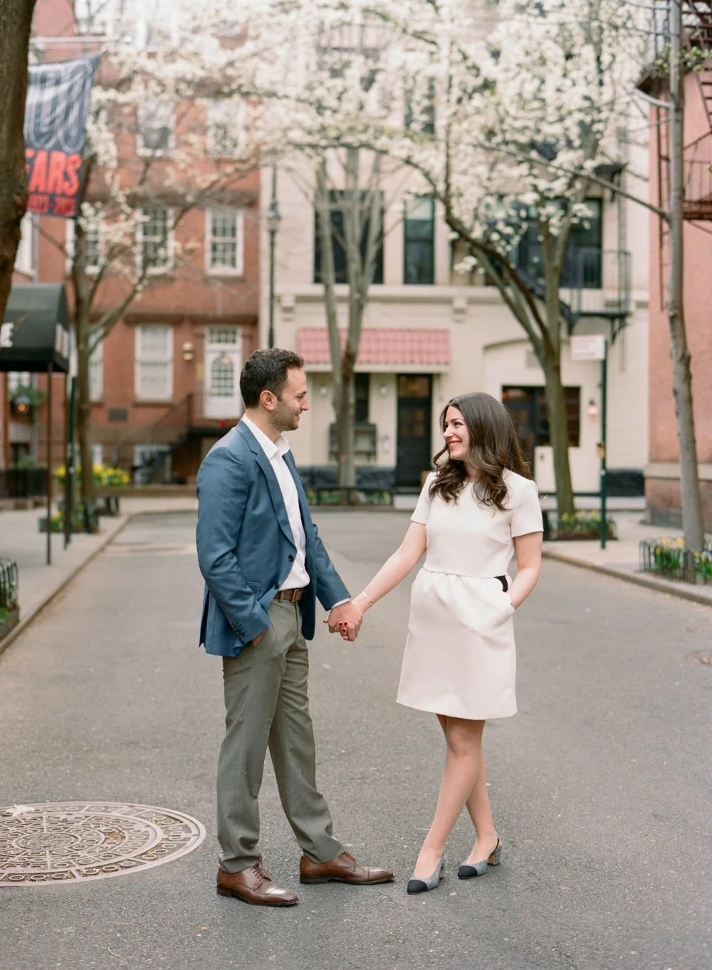  Stylish couple walking through quiet city streets during a timeless engagement photo session. 