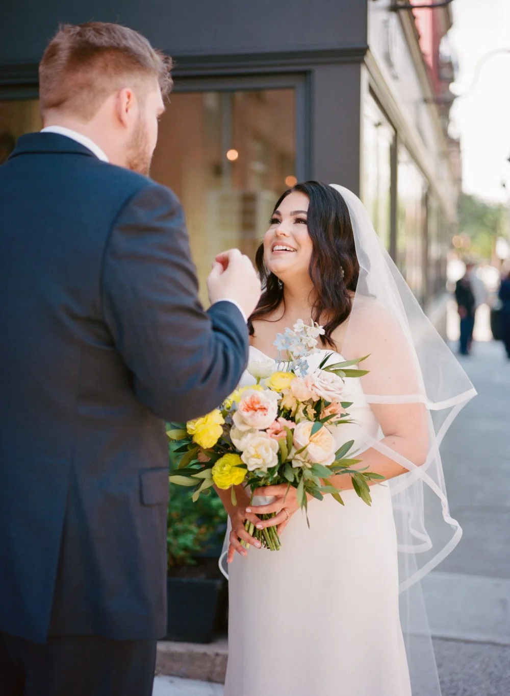 Bride smiling and laughing as she greets her groom during a joyful wedding moment. 