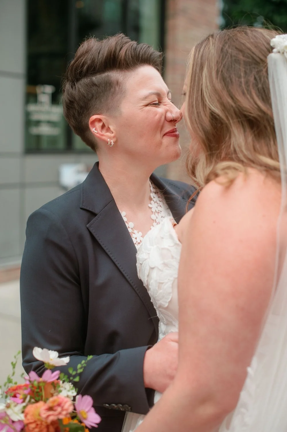  LGBTQ wedding photographer captures a joyful close-up of newlyweds sharing a quiet moment together. 
