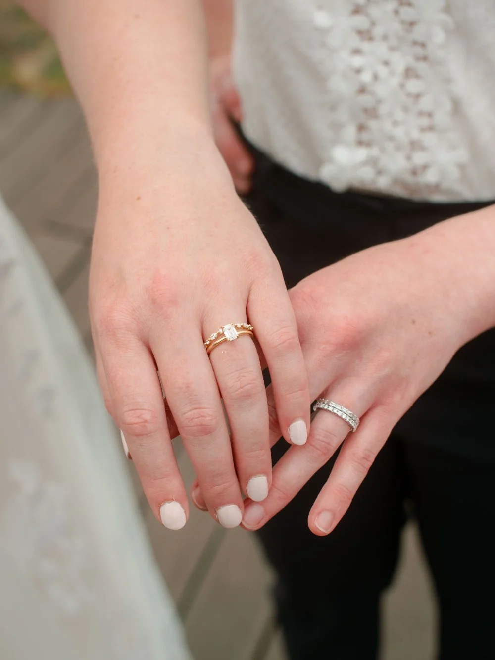  LGBTQ wedding photographer captures close-up of wedding rings as newlyweds hold hands after their ceremony. 