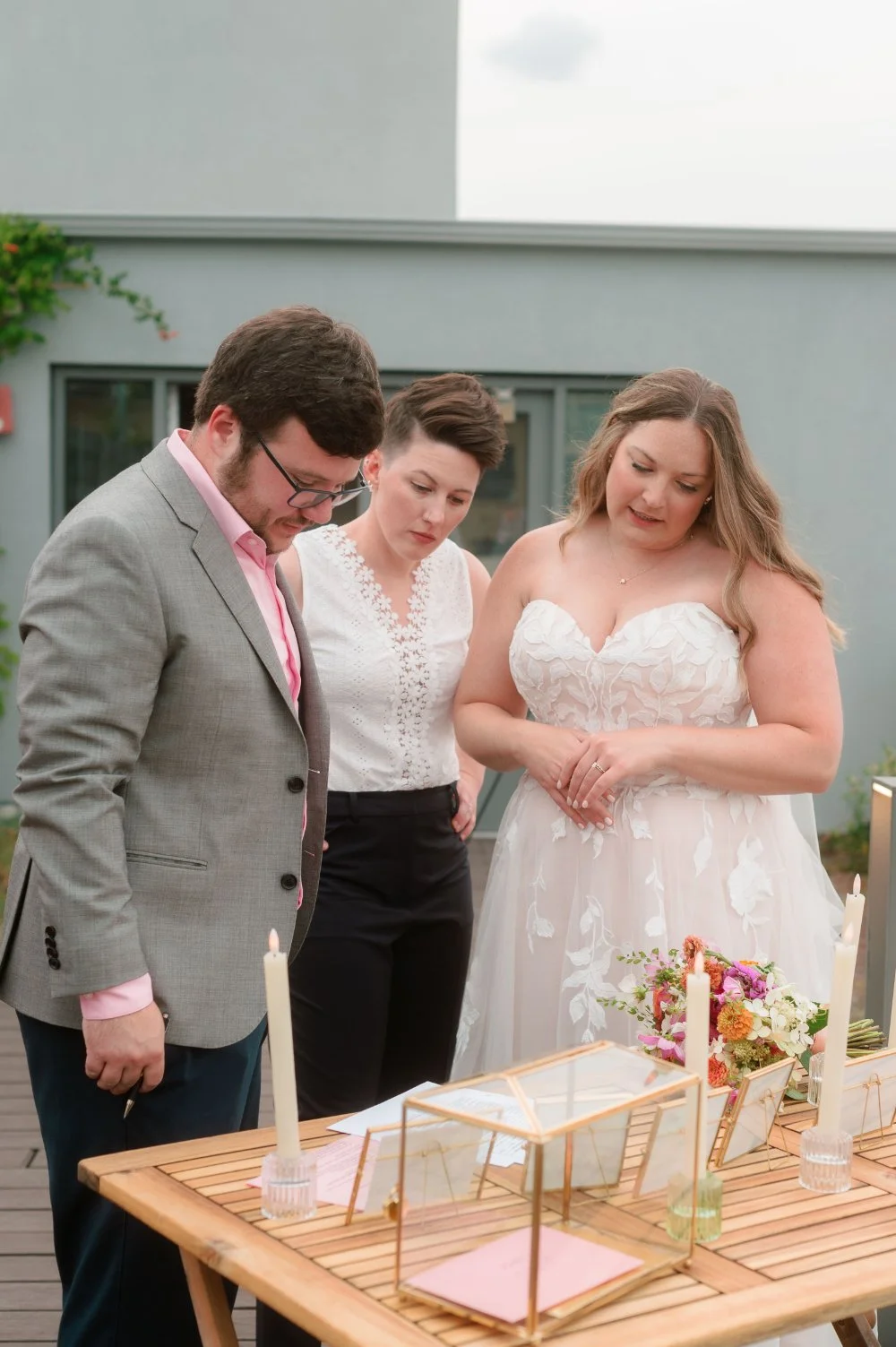  LGBTQ wedding photographer captures newlyweds signing their marriage license during an intimate rooftop wedding ceremony. 