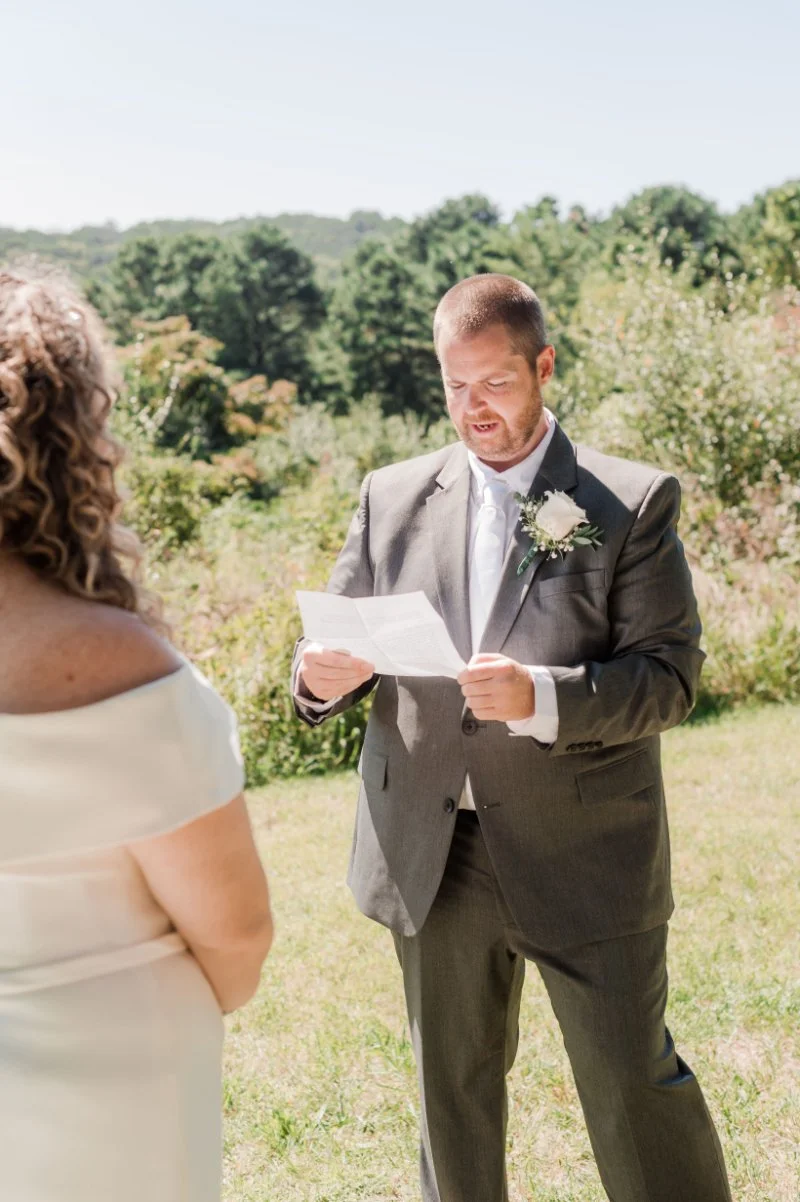  Groom reading his vows during an intimate outdoor wedding ceremony. 