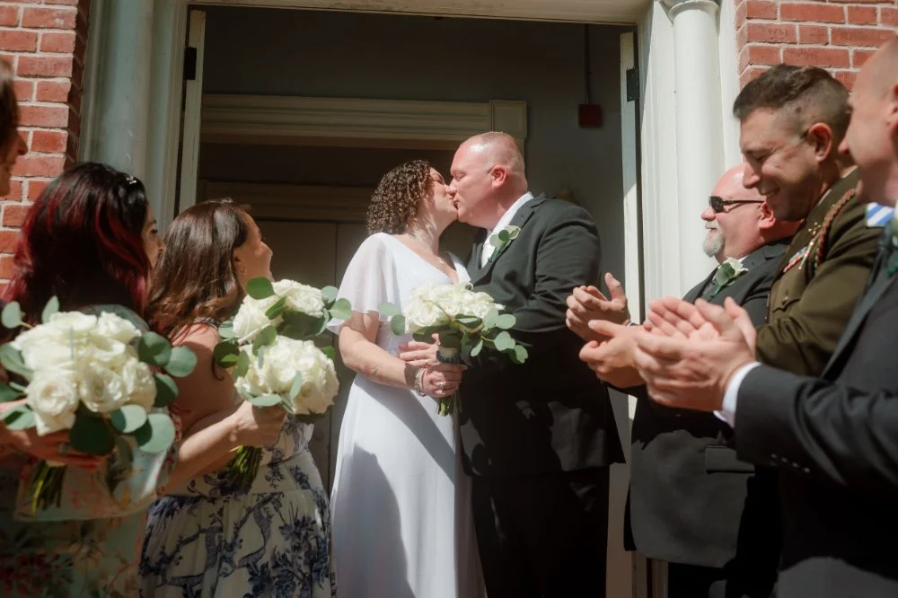  Newlyweds sharing a joyful moment with guests gathered around them after the ceremony. 