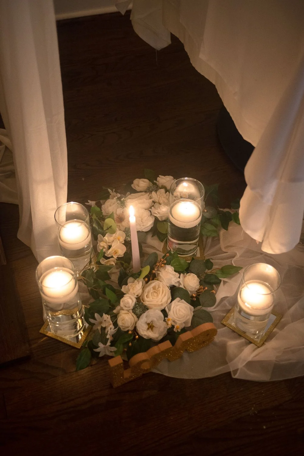  Romantic candlelit holiday wedding details with white flowers, greenery, and soft drapery, perfect for an intimate NYC or New Jersey celebration. 