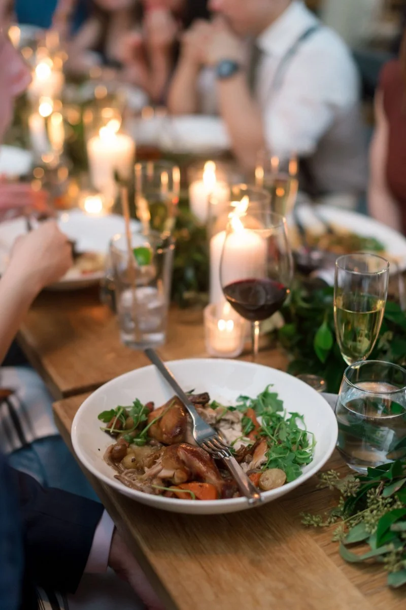Candlelit dinner table with shared meal and wine, a cozy way to celebrate with family after elopement