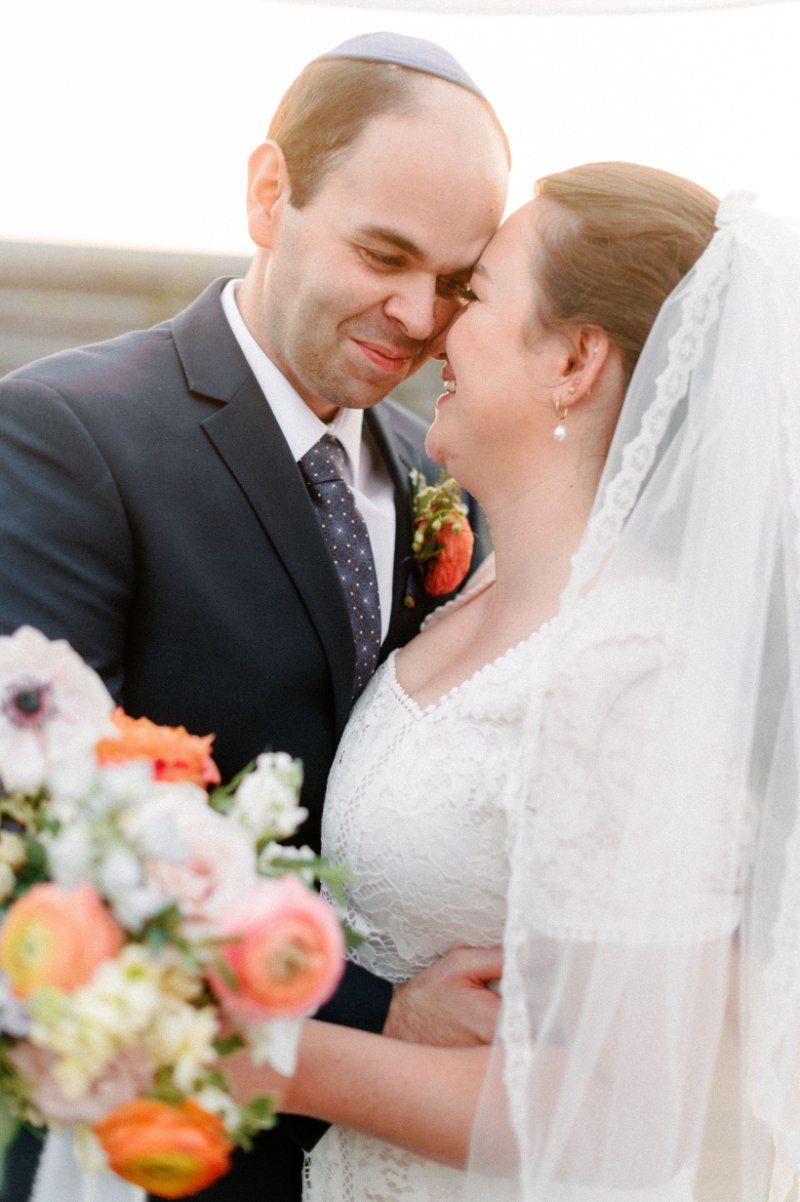 Bride and groom sharing a joyful, quiet moment after their big wedding exit on film.