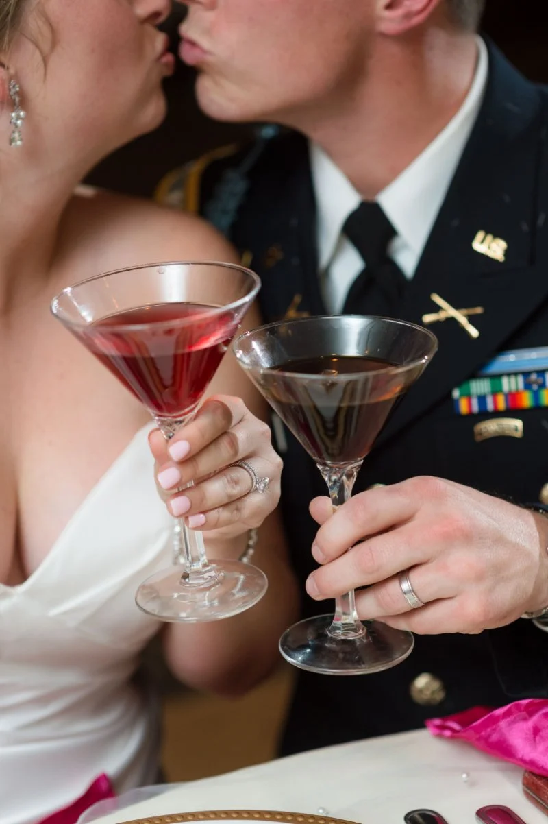 Bride and groom clink signature cocktails during a cozy toast alternative to a big wedding exit.