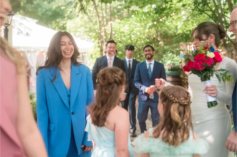 The bride chats with guests and flower girls, sharing laughter—vibrant, overlooked wedding moments full of joy.