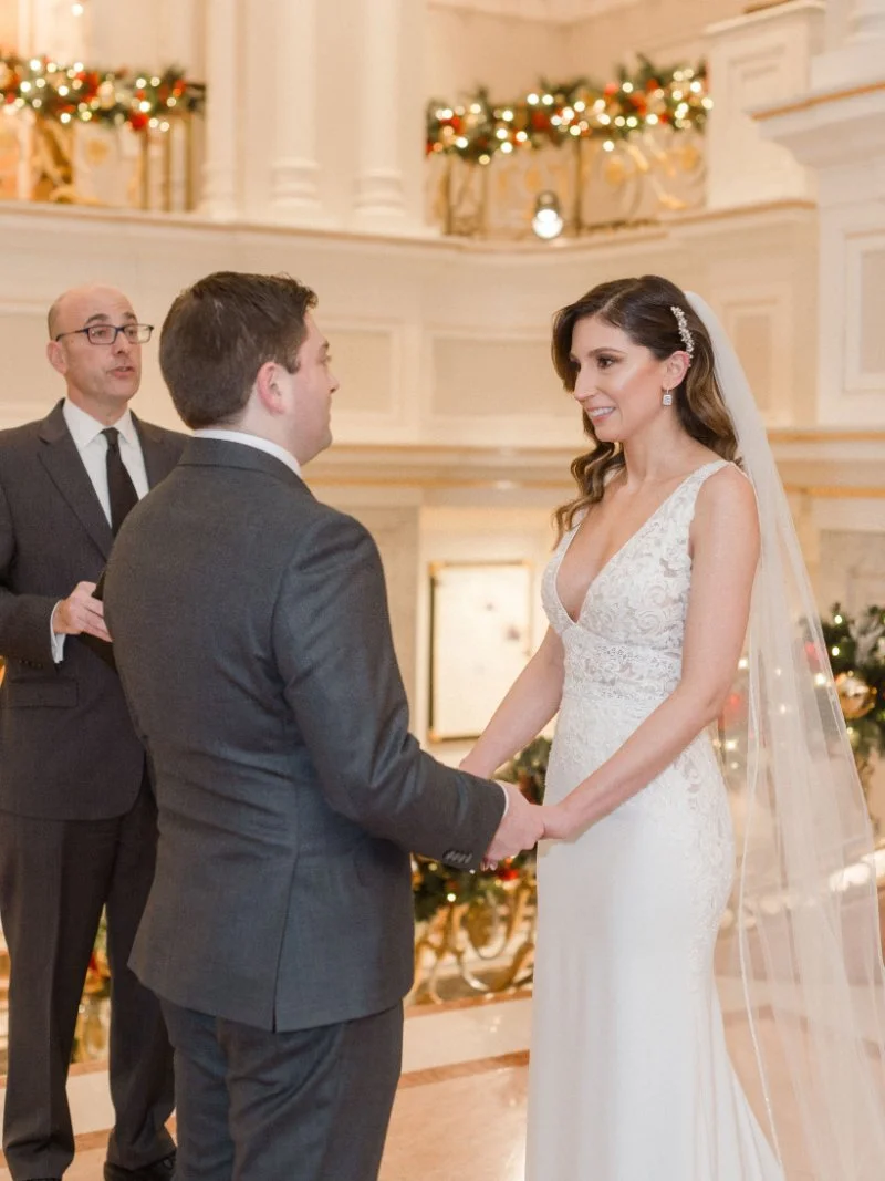 Bride and groom exchanging wedding vows during an elegant indoor wedding ceremony.