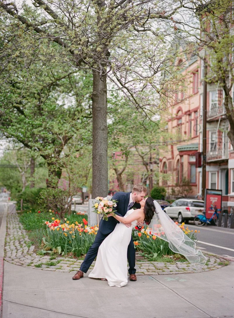 Romantic spring wedding in New Jersey with couple dipping kiss among blooming tulips and soft natural light