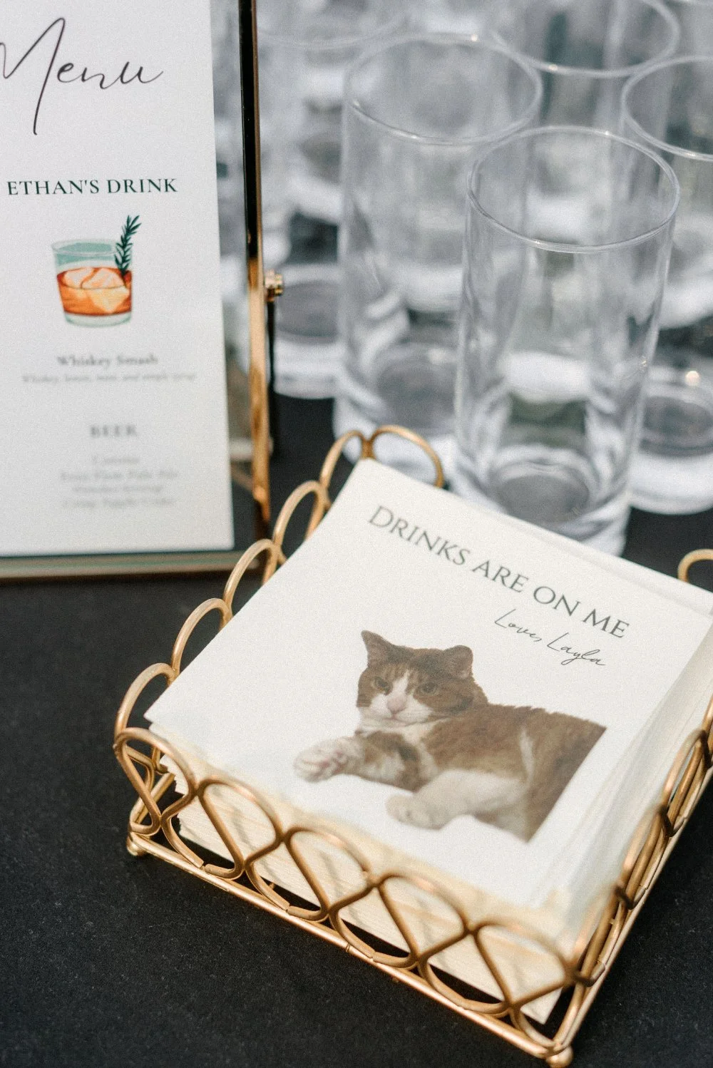 Signature drink menu featuring Ethan’s whiskey smash displayed beside clear glasses at the wedding reception.
