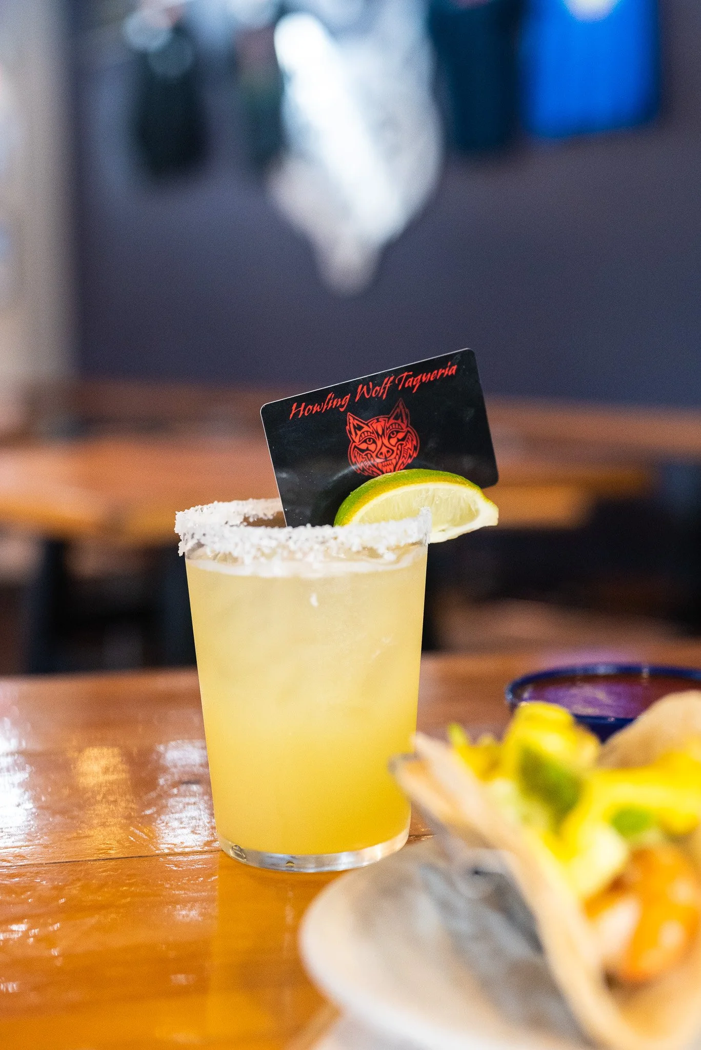 Margarita with a salted rim with a Howling Wolf Taqueria gift card in it