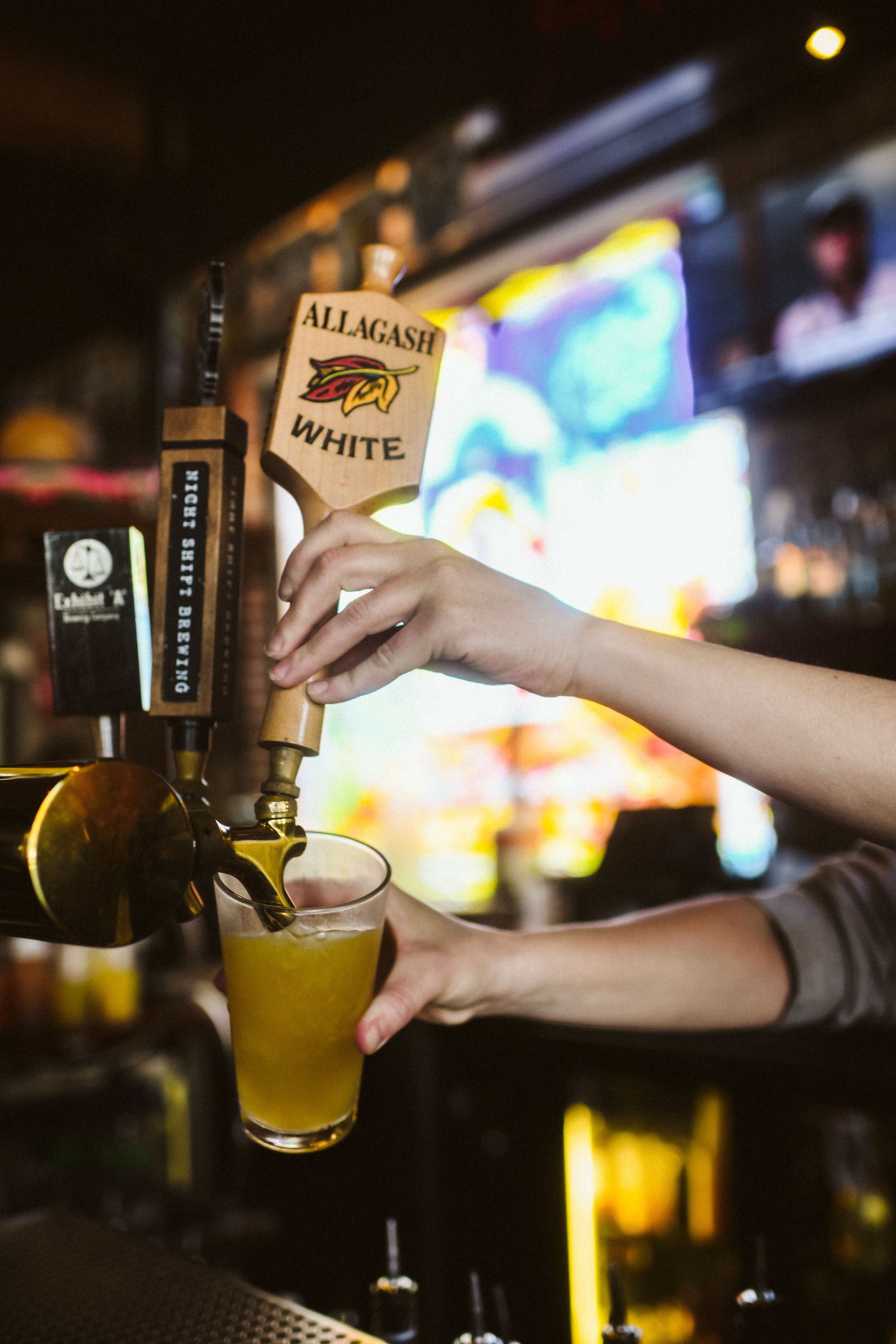 Bartender pouring a beer from the tap at the bar at Howling Wolf Taqueria