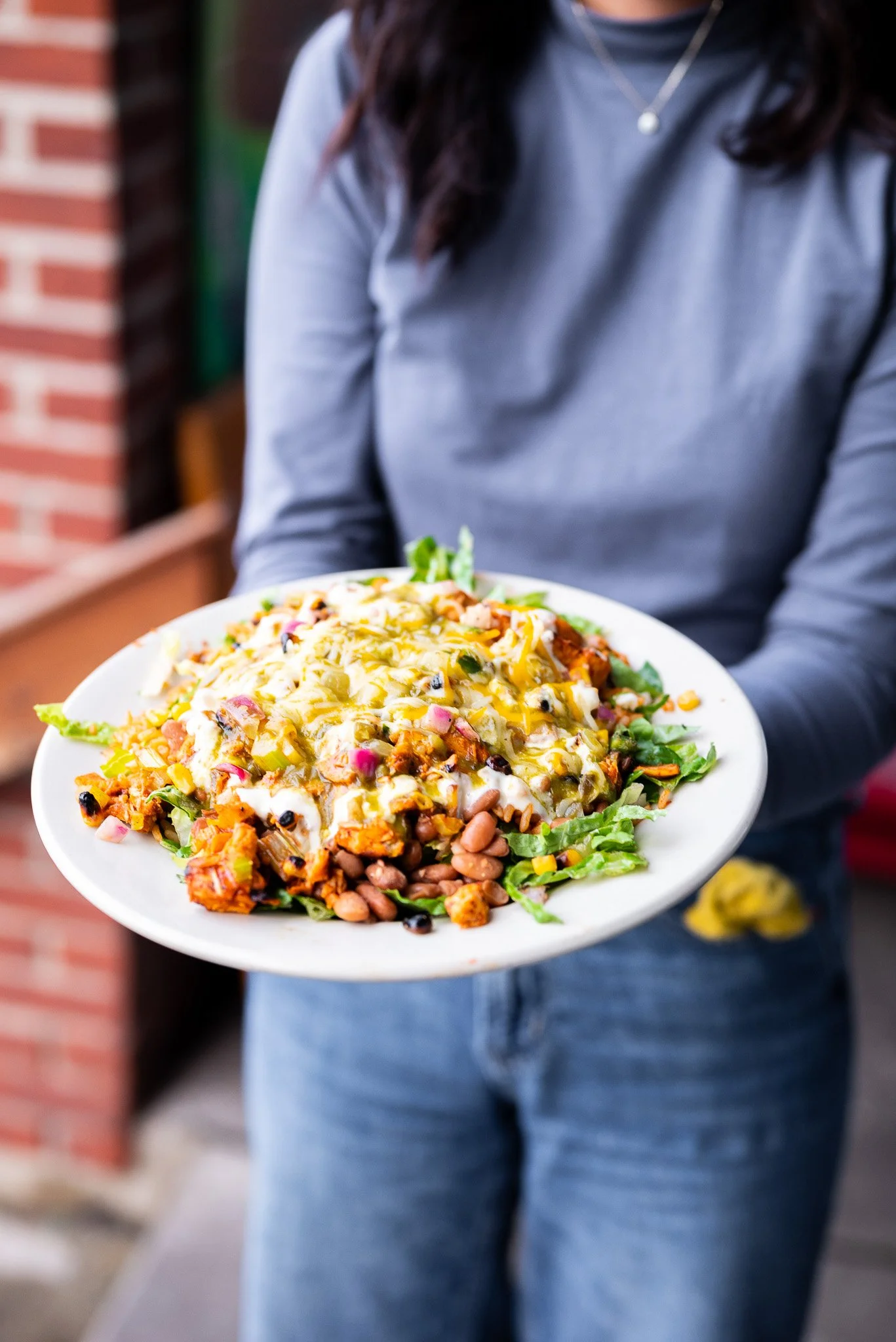 Person holding a plate of Mexican food at Howling Wolf Taqueria