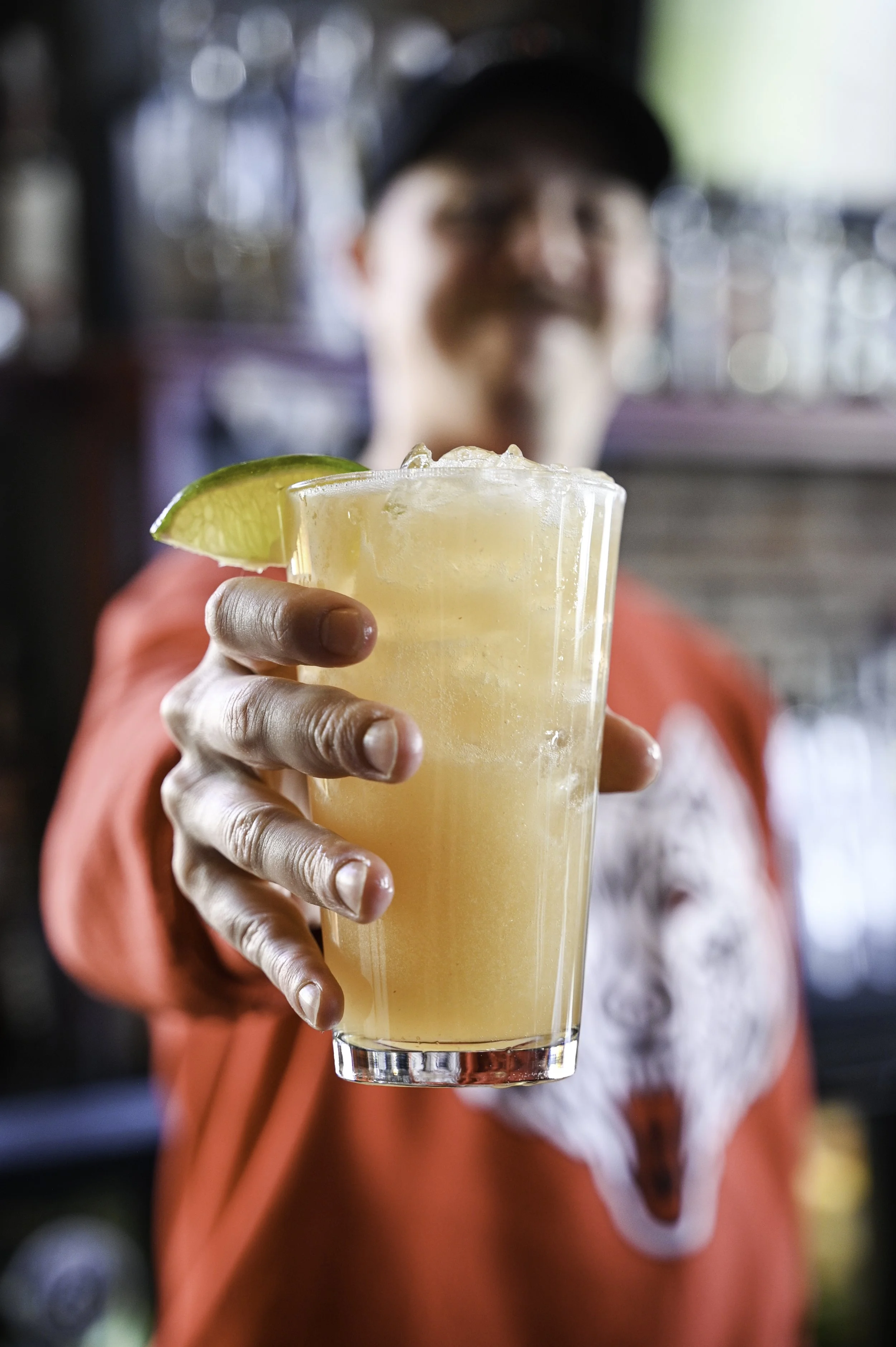Bartender holding out a margarita at Howling Wolf Taqueria