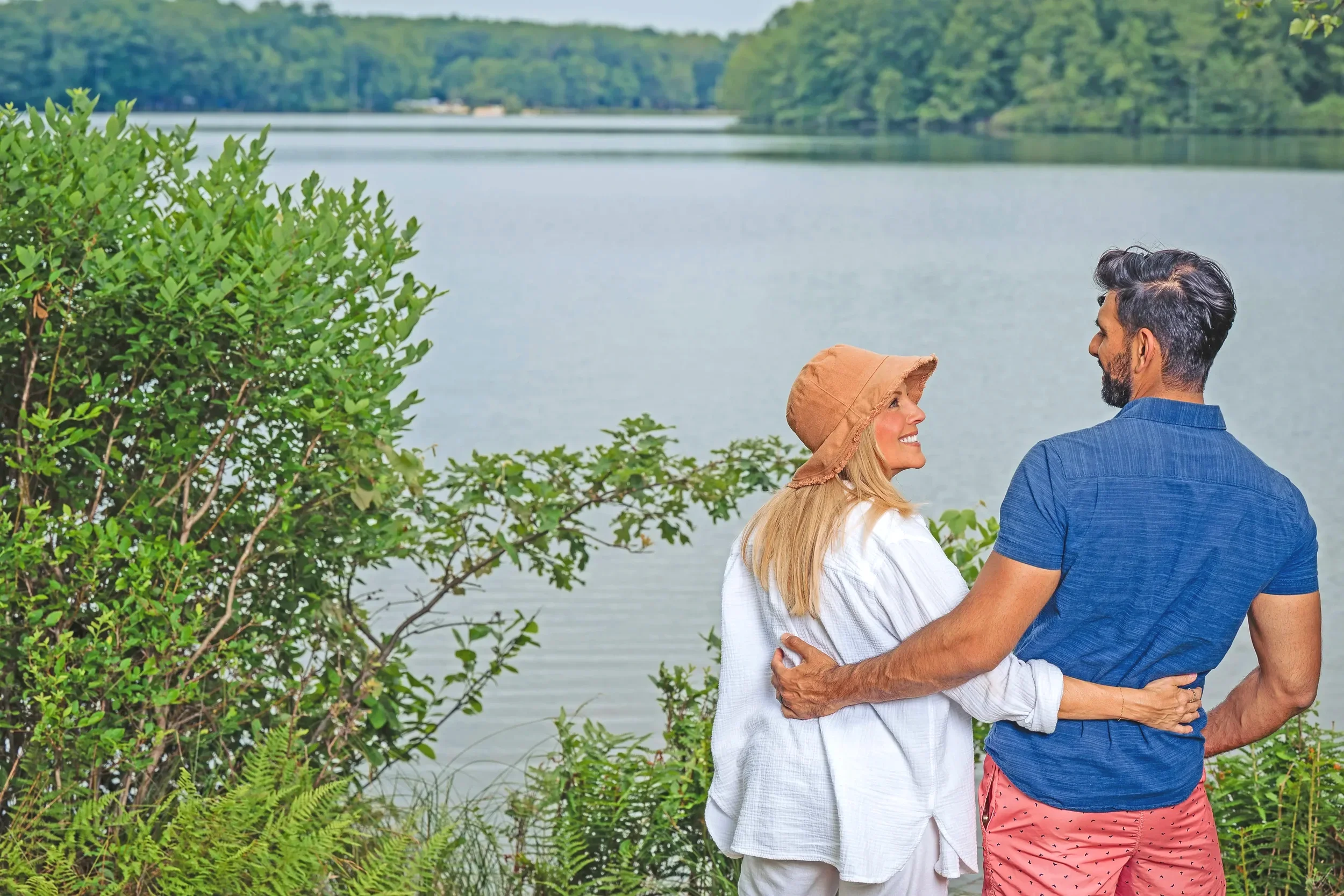 Couple embracing by a lakeside with forest views at Mountain Springs Lake Resort