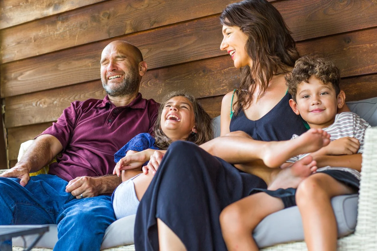 Couple relaxing with feet stretched out by campfire