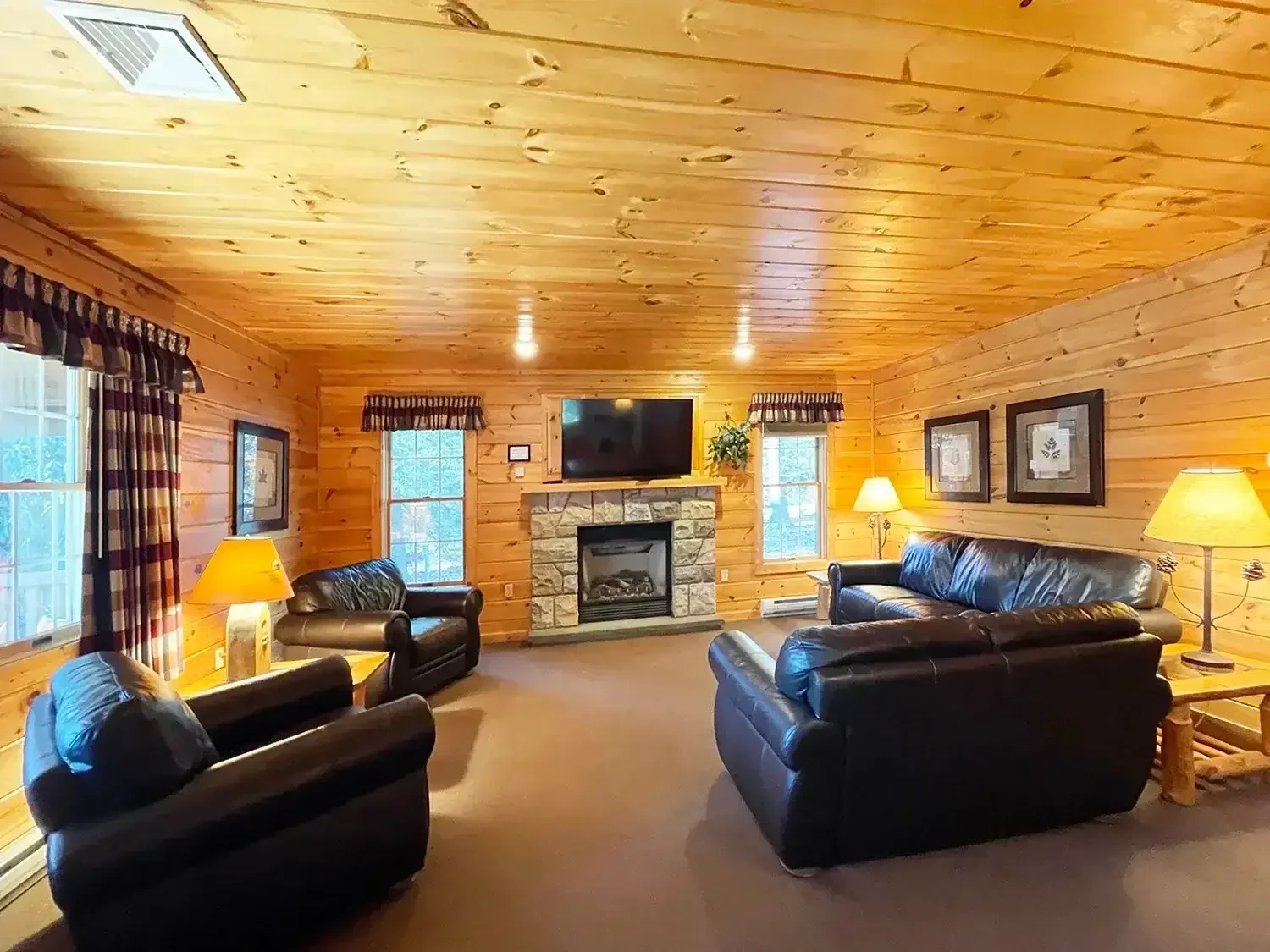 Cozy cabin living room with stone fireplace and warm wood interior at Mountain Springs Lake Resort in the Poconos