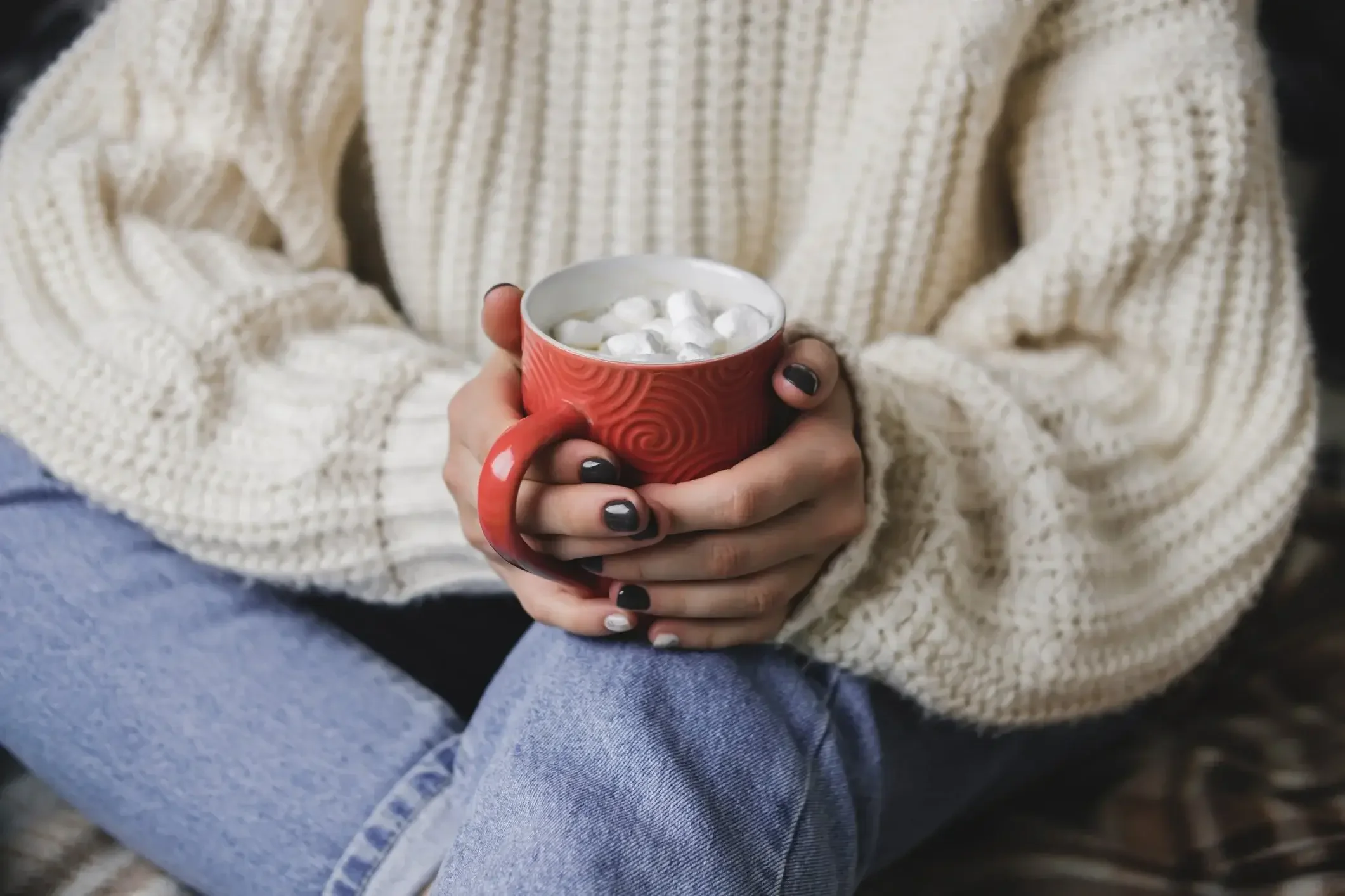 Guest relaxing with a warm cup of hot chocolate at Mountain Springs Lake Resort during a cozy winter getaway.