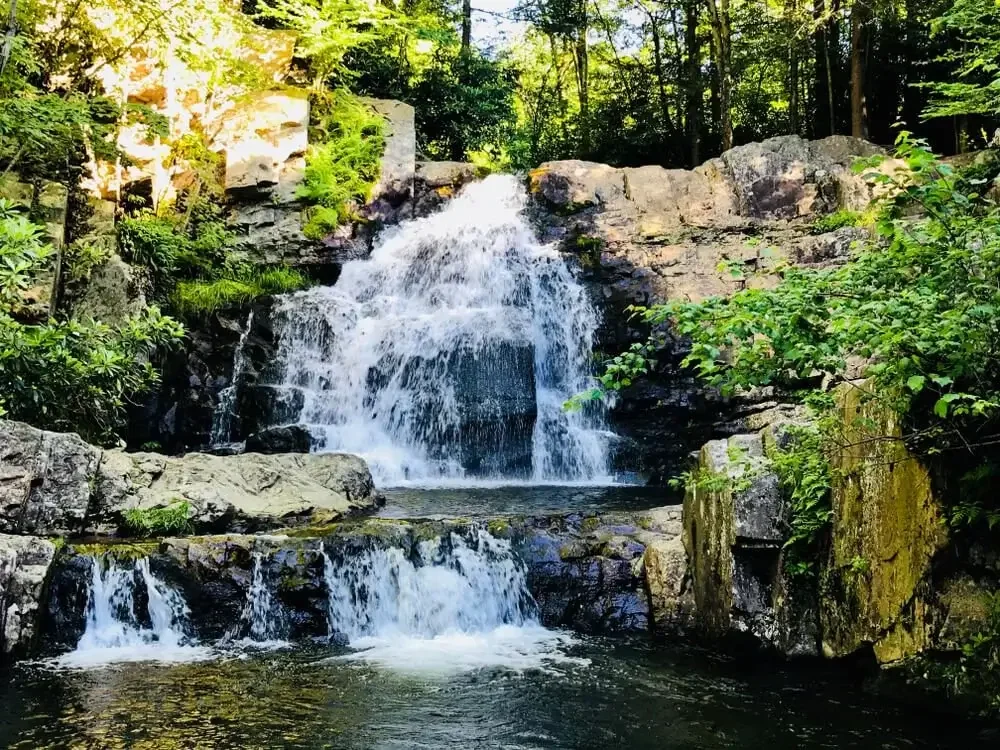 Waterfall flowing over rocky ledges surrounded by lush greenery in the Pocono Mountains