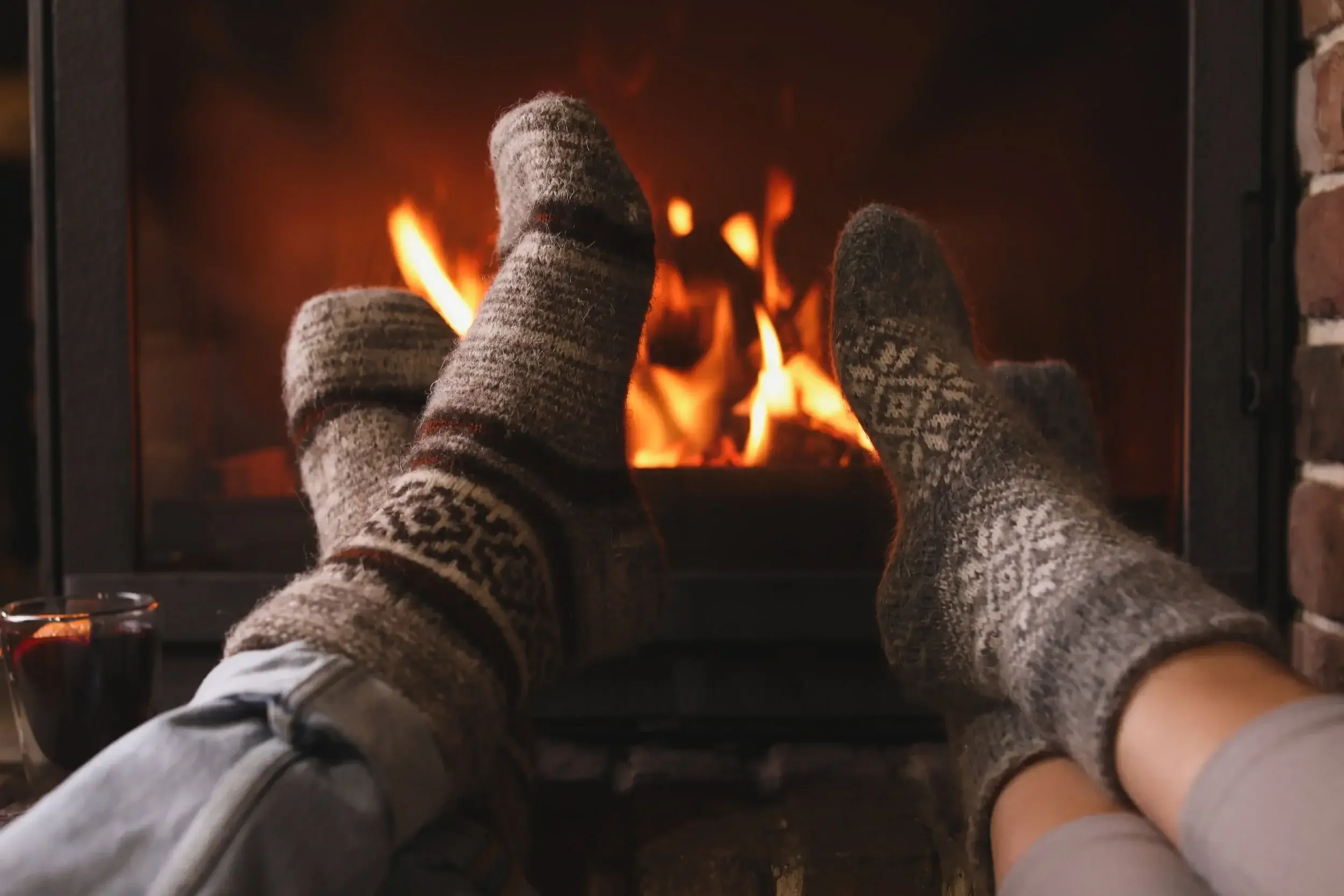 Couple relaxing in warm socks in front of fireplace
