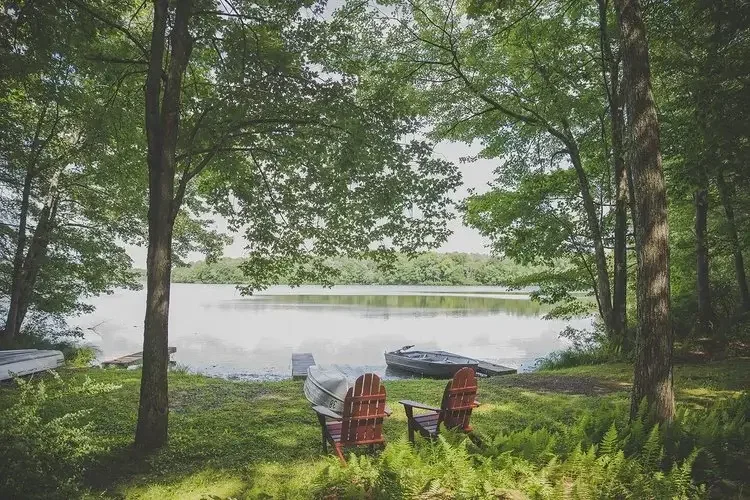 Adirondack chairs and rowboats overlooking Mountain Springs Lake