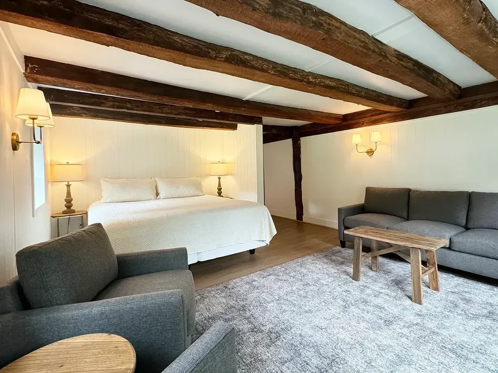 Apartment 19 living area with king bed and exposed wood beams