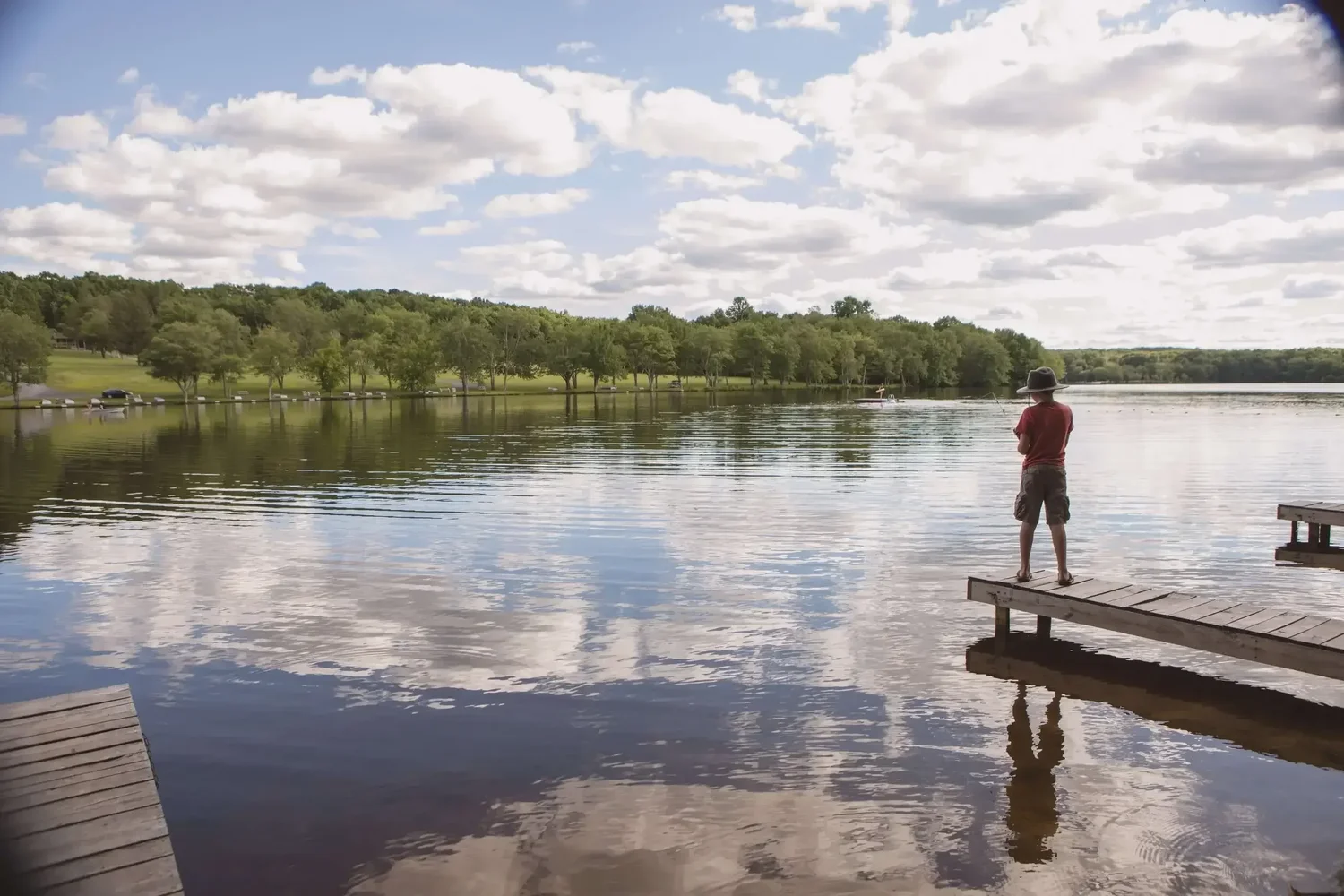 Family fishing from a dock on the private lake at Mountain Springs Lake Resort