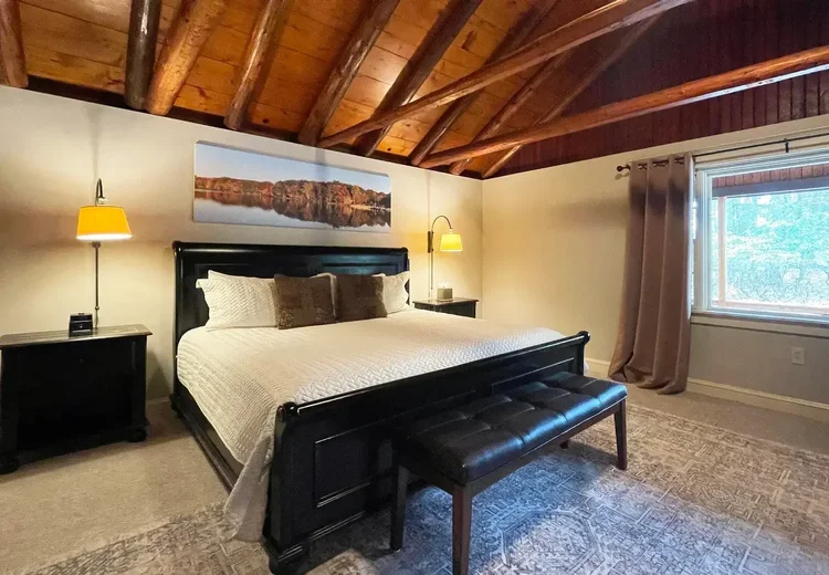 Warm bedroom with wood ceilings and cozy lighting for a romantic Pocono getaway
