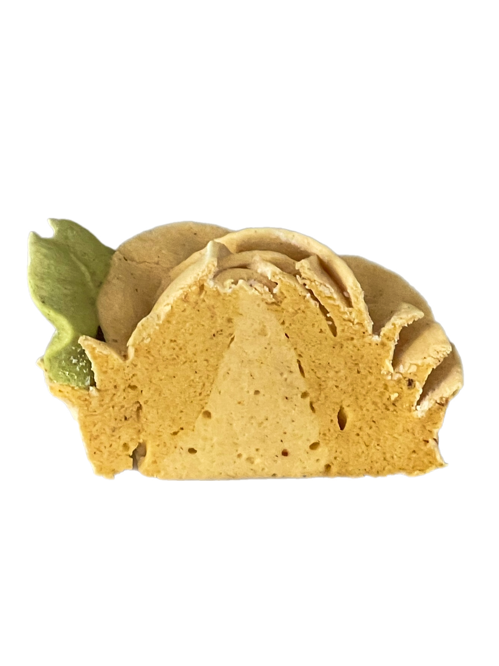 Close-up of a pineapple-shaped loaf cake with a green pineapple leaf on top, featuring a golden-brown crust and a light yellow interior.