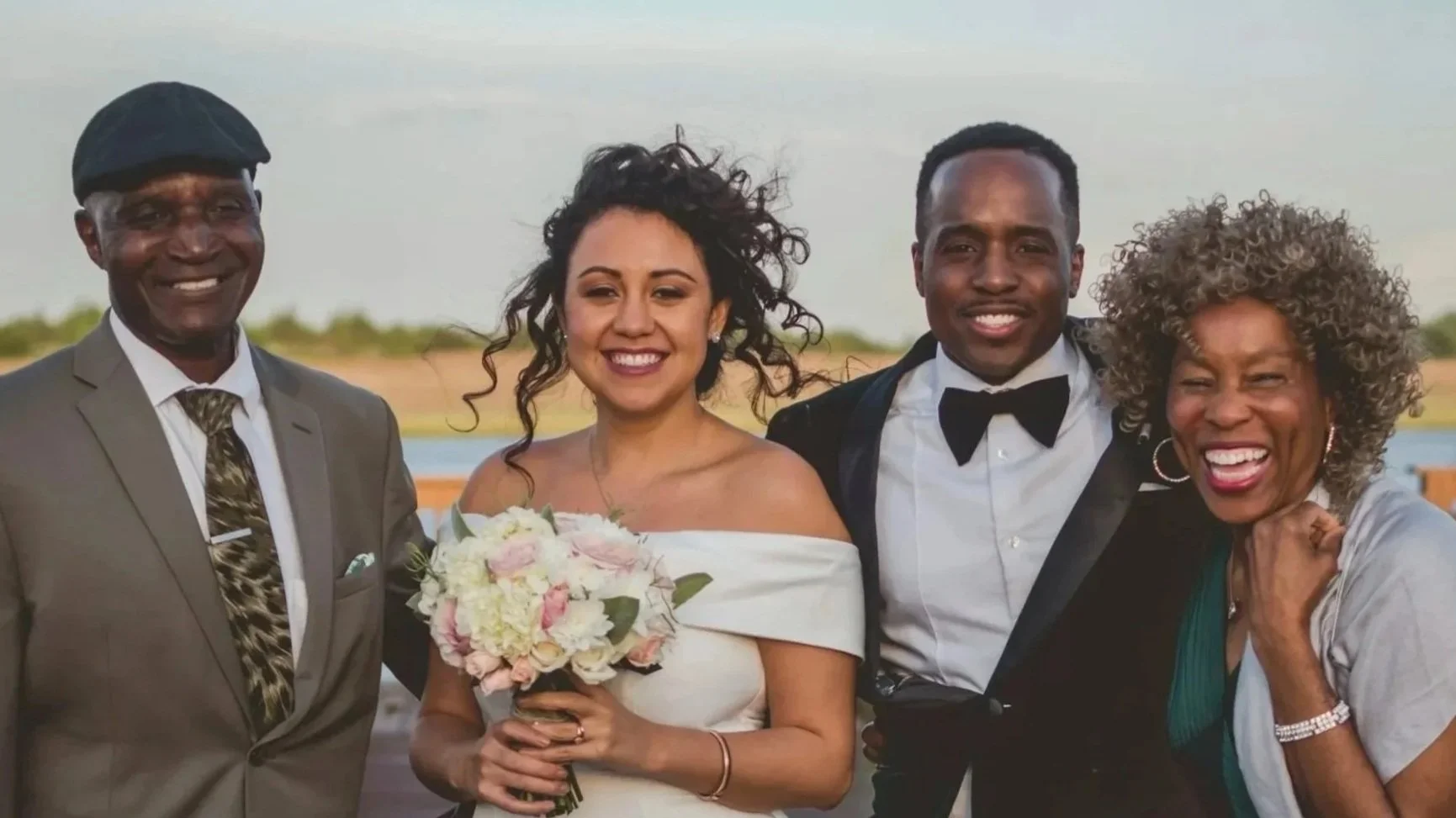 Couple surrounded by a set of parents, smiling
